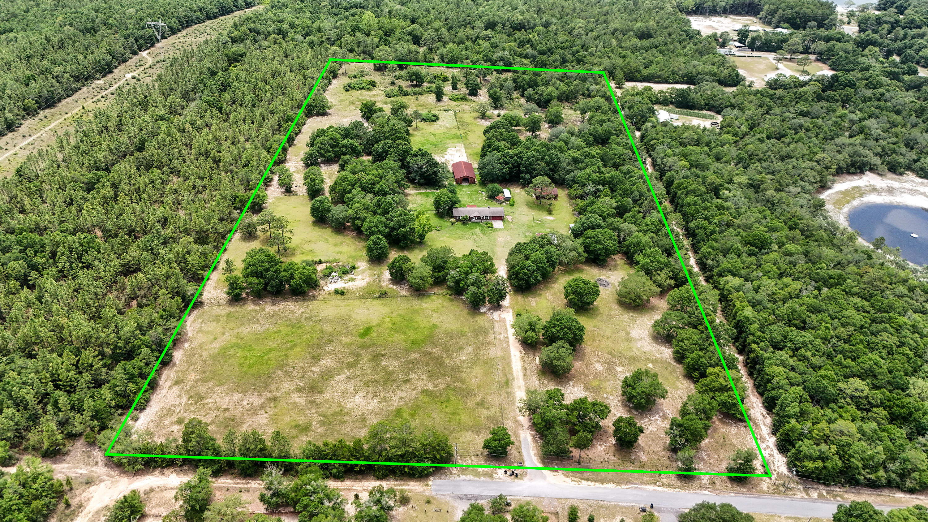 Location is everything! Attention Developers, Horse People and those looking for acreage 5 minutes to downtown DeFuniak Springs: A rare find! 19 acres tucked away at the end of a quiet road, sitting high on a hill with unexpected vistas. With a serene country feel, you're actually abutting the city limits with the real option to annex. Zoned Urban Residential with a density of 2 dwellings/acre, with city water access (would require septic), making it a smart option for what could make a very special development of up to 36+/- lots. Or if you'd rather keep it all to yourself, it's set up for horses with a 5-stall barn, fencing and cross fencing, and a mix of open space and shade. Use the brick 3 bed/2 bath home as-is, rent it out, or live in it while you build out your vision for the land.