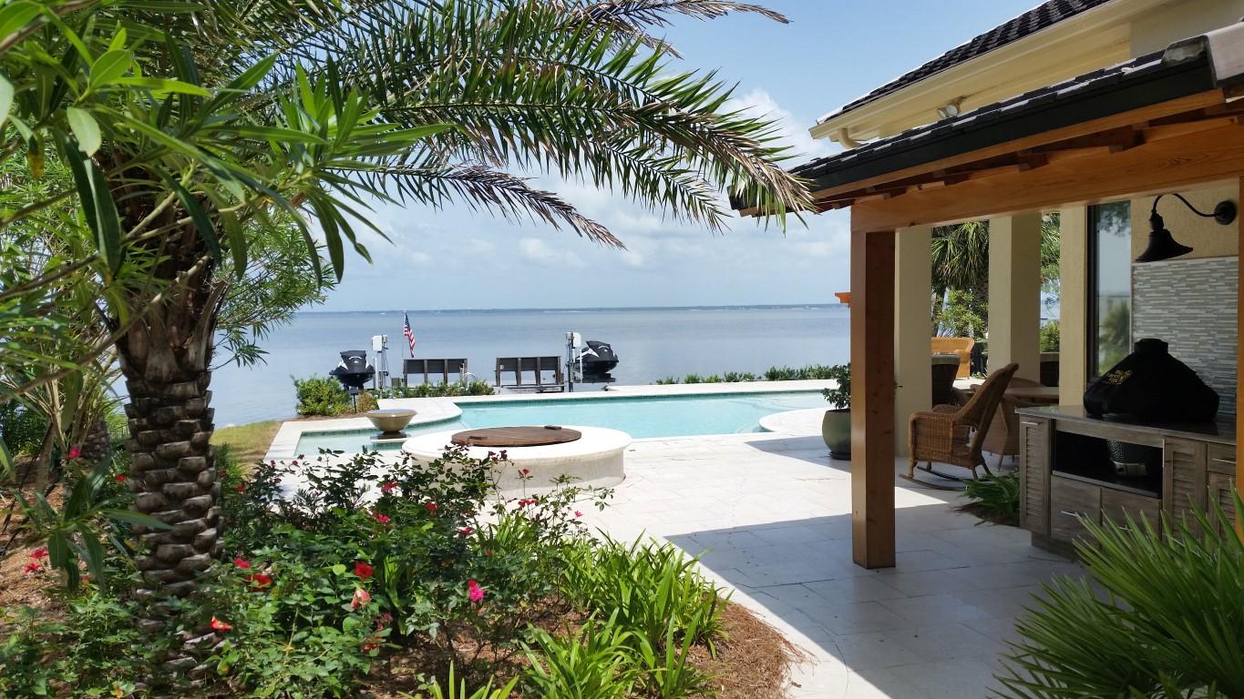 Bay front home in Burnt Pine with many features and amenities: boat dock with lift, heated, saltwater pool, elevator, large patio space, open floor plan with multiple views of the bay, large two car plus golf cart garage