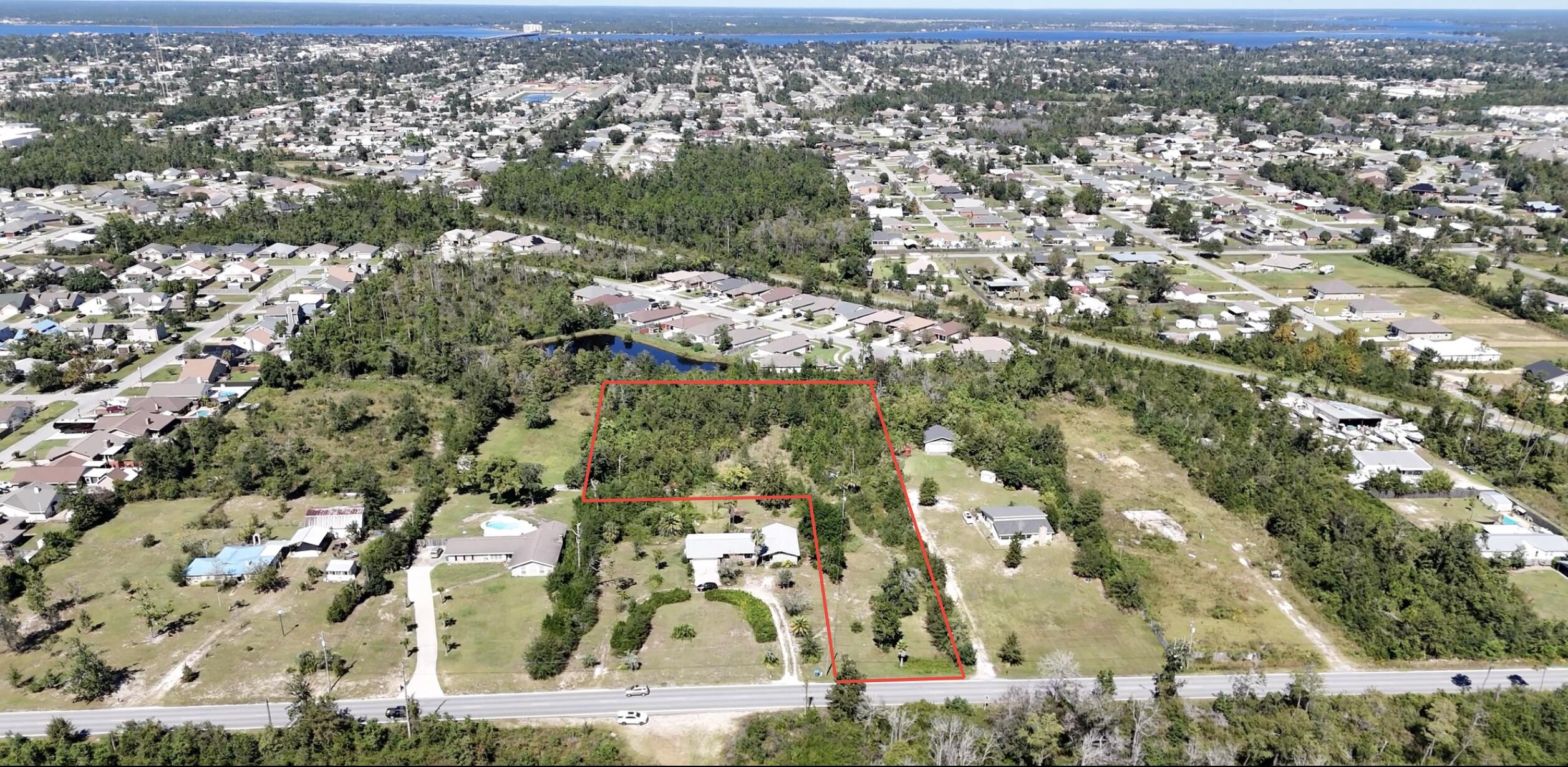 Incredible Opportunity here! Seller is also selling the adjacent home on 1.09 acres MLS 961911 - will consider selling together - house is in blue outline, land is in red outline, outlines are approximate - buyer will need to verify dimensions. This listing is for a flag-shaped 2.99 acres parcel, vacant and undeveloped land and ready for your creativity, design, and dream. This is an investor's playground, ready to be developed and tons of potential here. The property allows horses and can also have multiple homes here, such as a small neighborhood or small community. The land is near a pond in the back but the pond is not included in the land. Please see aerial maps. The land has beautiful mature trees and tons of opportunity here.Zoning R-1.  The land does not have but will need private well and private septic. 

Future Land Use per Bay County Comprehensive Plan (Buyer is still advised to complete their own due diligence) states the following:  Allowable Uses: Those land uses typically associated with residential occupancy including single-family, duplex, triple, quadraplex, condominium, townhouse, apartments, cooperative, manufactured housing and public facilities.  Public utilities, recreation, conservation.  Limited public institutional uses and educational facilities.  Density housing: urban/coastal - no more than fifteen (15) dwelling units per acre, Other Urban - up to twenty-five (25) dwelling units per acre contingent upon availability of facilities and services. Suburban -  no more than five (5) dwelling units per acre contingent upon availability of facilities and services.

The buyer is encouraged to obtain a current survey.  Please contact Bay County for development guidelines and what is allowed.  