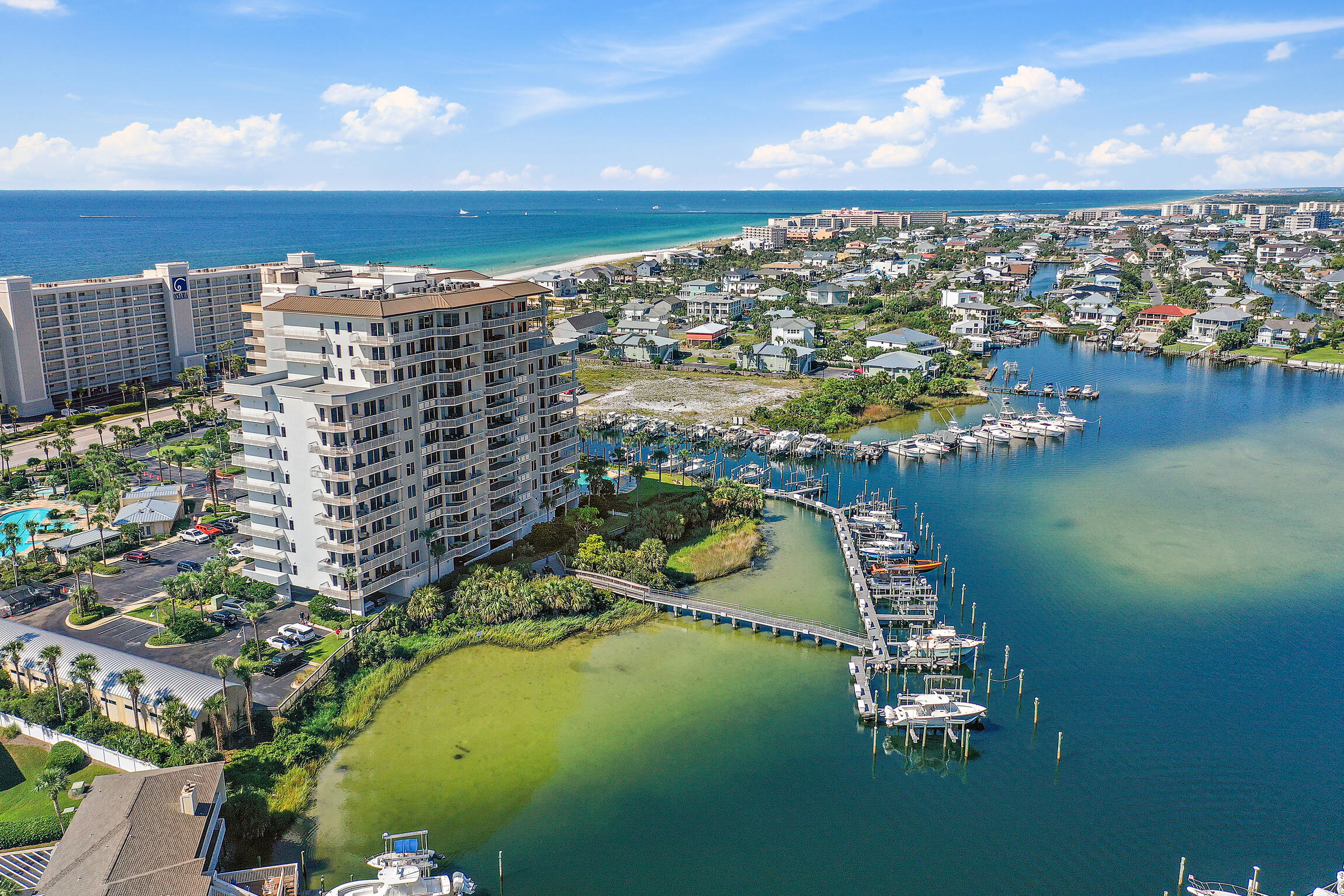 Riveting 270 degree views of the gulf and harbor from this spectacular end unit in Harbor Landing.  Catch the full beauty of the turquoise water and white sand beaches or the super brilliant life of the harbor while sitting on your oversized covered wrap around balcony.  Spectacular sunsets, weekly fireworks, holiday boat parades, and wildlife including manatee, dolphin, osprey, and pelican will entertain you, your family and your friends.  The owners recently renovated this 3 bedroom, 3.5 bath extensively.  New custom cabinets and backsplash, all new Kitchen Aid appliances including a 36'' induction cooktop, and custom hood vent with remote control all add distinction to this gorgeous white kitchen with new white quartz countertops. Elegant new lighting, mirrors and fans along with custom toe kick lights under the cabinets pair exquisitely with the fresh coat of paint everywhere.  All the bedrooms have new high end carpet with plush padding for comfort.  Harbor Landing offers the best of Destin, with private deeded beach access, a marina on property with harbor access to the bay and the gulf, two pools, a hot tub, a workout center, and a clubhouse.  New water heater in 2023, new AC condenser in 2024 and all new Kohler self cleaning toilets.  LG front loading washer and dryer, new in 2023, included in the sale.  List price is for the condo only.  A 45 Ft boat slip with 30K lb lift is available for additional purchase price.  