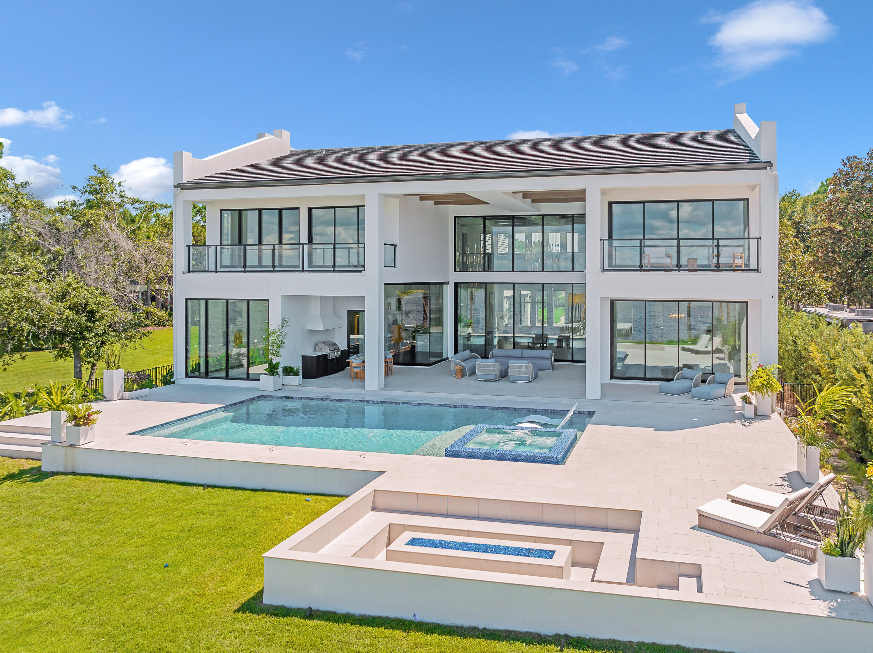 Imagine living in this prestigious custom-built home by renowned builder Norm McLean. Reached along a lengthy gated driveway, this recently completed coastal contemporary home occupies an oversized lot with a gated winding 400 ' drive and breathtaking 180-degree views across Choctawhatchee Bay. The private jetty awaits your boat and jet skis while the elevated deck provides compelling sunset vistas year-round. The white stucco home is softened with hints of wood and white brick while the metal and glass front door hints at the artful interiors yet to be revealed. A series of covered rear patios, porches and glass-enclosed balconies along with an astonishing two-story wall of glass deliver sensational bay views.