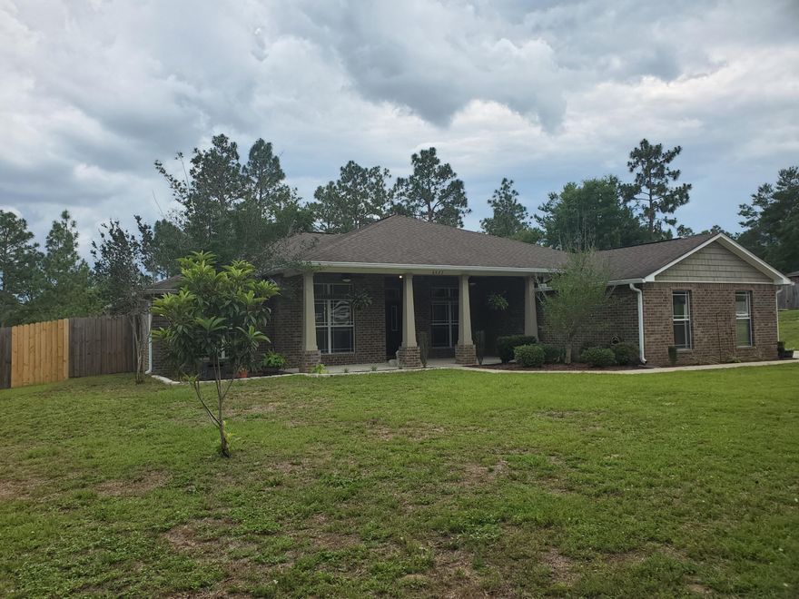 Just a little bit COUNTRY and near town! Lovely 4 bedroom 3 bath home situated on 1.22 privacy-fenced acre a short distance north of Crestview. The land boasts of a variety of fruit trees and wild berries including loquat, peach, plum and pear trees...blueberry and dewberry bushes. Great bonus is well water for gardening. The home has fresh interior paint, some new flooring, light switches, LED bulbs, fire alarms and a new hot water heater.  Plenty of kitchen cabinets with granite counter tops.  The separate dining room has a replica of a famous painting by Van Gogh the ''Almond Blossom'' and a complimentary light brings a private ambiance to dining. Master bath has a garden tub with modern tile, separate shower and twin closets.  Yellow River Plantation provides outdoor activities