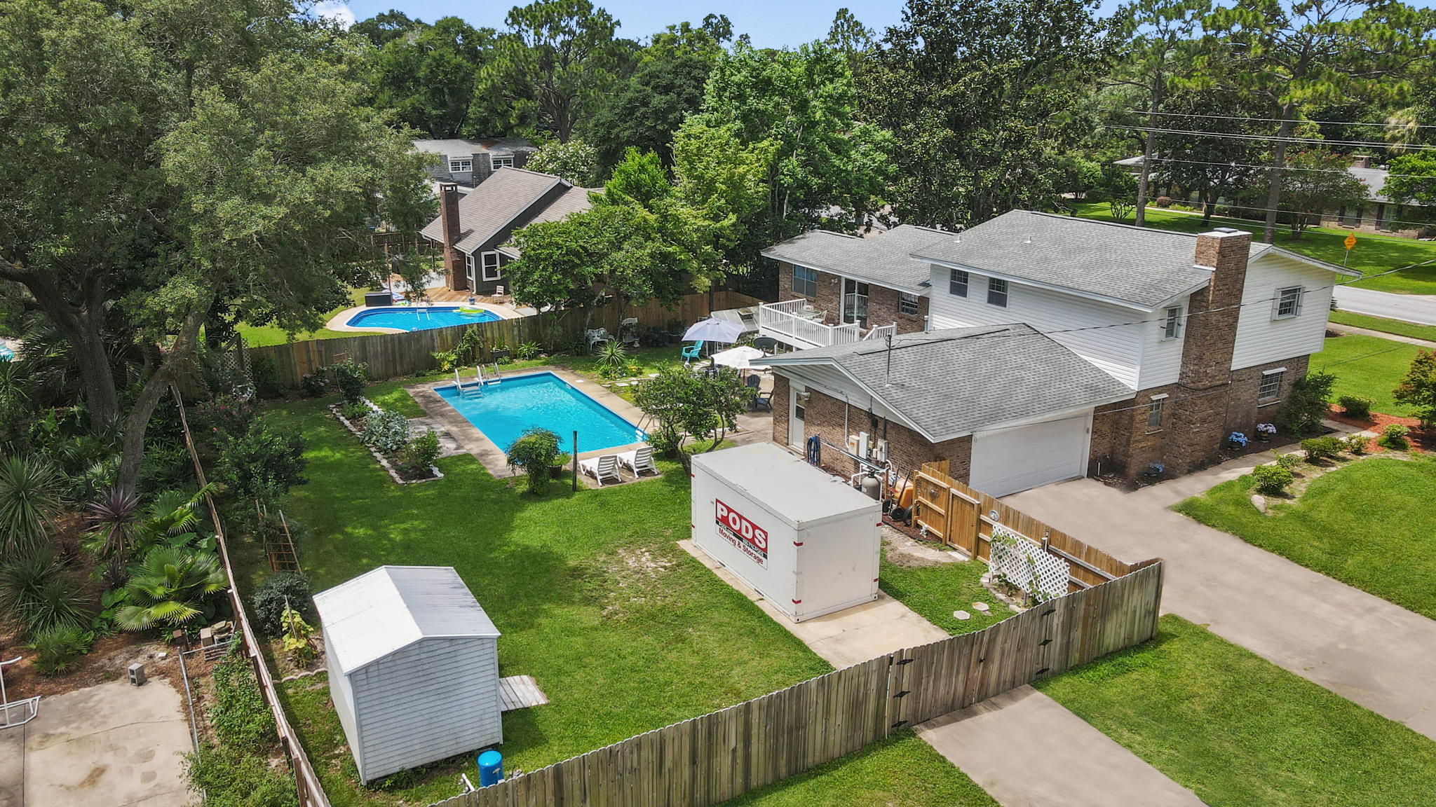 Charming split level home with in-ground pool, privat RV/Boat pad & electrical and more! Seller offering Home Warranty! The 1st level boasts a wide-open living space accented by a bold brick fireplace, vinyl flooring, a cozy bedroom, a full bathroom with tile flooring, ample natural lighting and access to the oversized 2 car garage w/ hurricane door. The kitchen and formal dining room are located on the 2nd level / main floor. The kitchen has been updated with quartz countertops, beautiful dark cabinetry with modern hardware that offer ample storage, stranded bamboo flooring and access to the outside deck that has recently been updated with high-performance composite