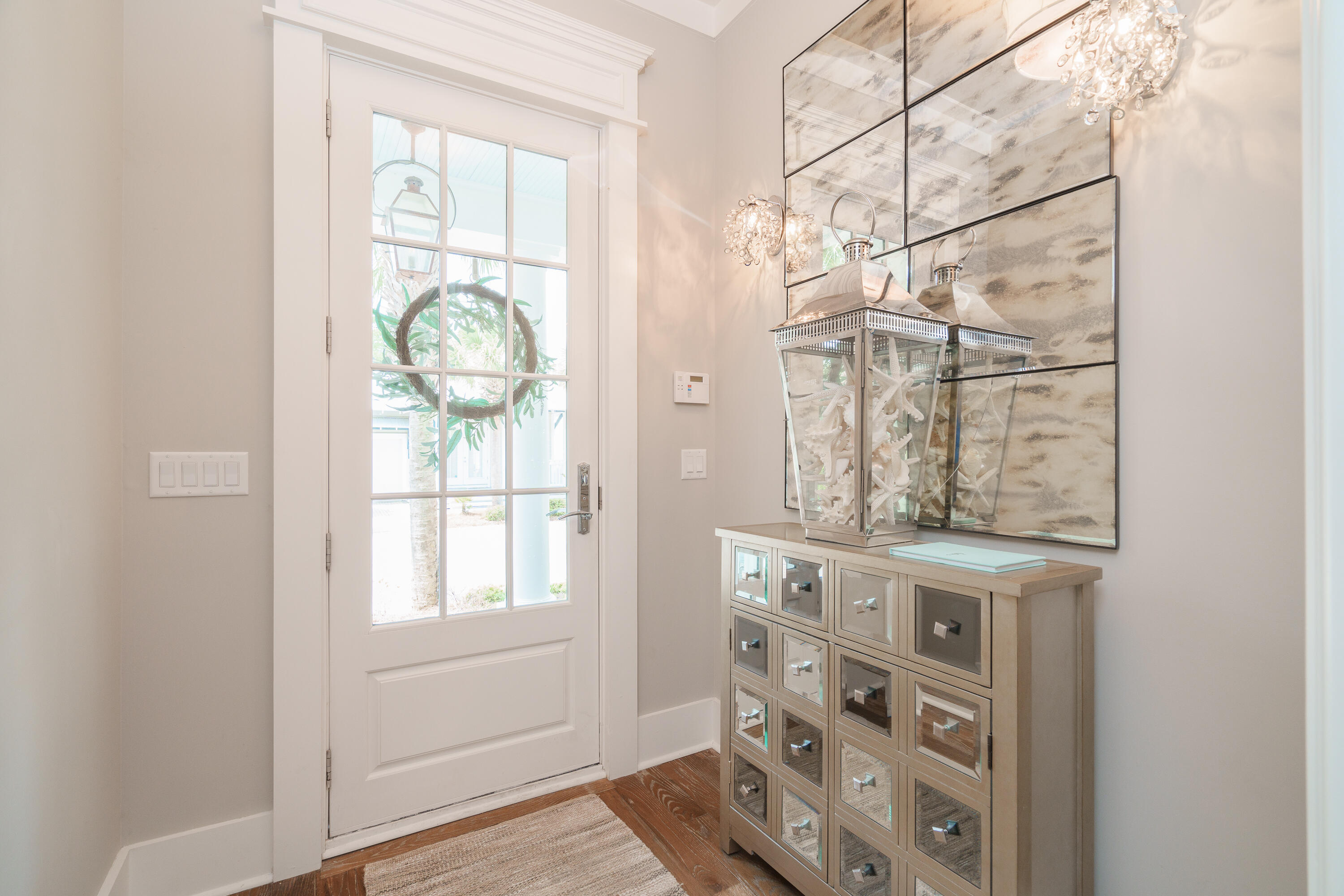 Sitting along a charming brick paver street, this property provides a personal touch that showcases warm textures with a coastal aesthetic. Upon entry off of your southern style front porch you are greeted with an arched foyer highlighting an extended hallway with hardwoods throughout. You will find the primary bedroom and en-suite on the main floor. The primary has large windows for natural lighting, complete with custom window coverings and eleven foot ceiling heights. The en-suite holds a walk-in closet, dual vanities, a deep soaking tub, and a marble walk in shower with glass enclosure. Down the hallway is a guest half bathroom and a laundry room. Arriving into the living area, it is an open kitchen to living concept with an additional sitting area and dining space in the back. A popular layout for entertaining. The living space features a warm, gas fireplace with shiplap accent walls. The kitchen comes equipped with a pantry, gas stove with a custom built range hood, ice maker, and stainless steel appliances. The Quartz countertops compliment a stunning backsplash and the kitchen island provides for additional seating and counter preparation space for large parties. Head upstairs to find two additional built in bunk beds in a charming, cozy nook off of the hallway. All three bedrooms maintain a private bathroom, which could be an ideal layout for a short term rental! The bathrooms each have marble flooring and shower accent walls throughout. There is additional storage upstairs as well as an exterior storage unit off of the carport. The details in this home truly stand above and include solid wood doors, crown molding throughout, high-end dishware and appliances, custom lighting and draperies, plus more! This neighborhood sits just minutes from the beach and provides a community pool to all owners and guests. This community does allow for short term rentals, although his home was used strictly as a second home in previous years.