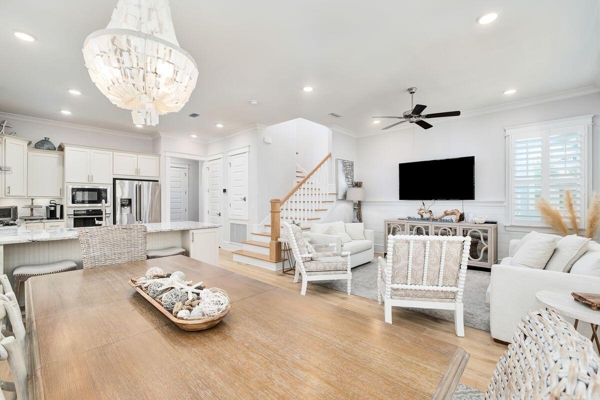Located south of 30A, this beautiful 2019 beach house is offered furnished and comes with several outdoor porches and many extras. Check out the plantation shutters, tankless water heater and crown molding along with the cool coastal decor. Step onto the front porch where a swing loveseat invites you to linger. It's the perfect outdoor space for lazing and reading in the shade. This contemporary home has a popular floor plan including a master suite with generous closet, ensuite master bath, guest bathroom and laundry all on the first floor. Hardwood flooring, shiplap and wooden stair treads add a touch of nature to the bright living area which has well-defined areas for dining, entertaining and relaxing in front of the 65-in. smart TV. Another generous porch for alfresco dining and