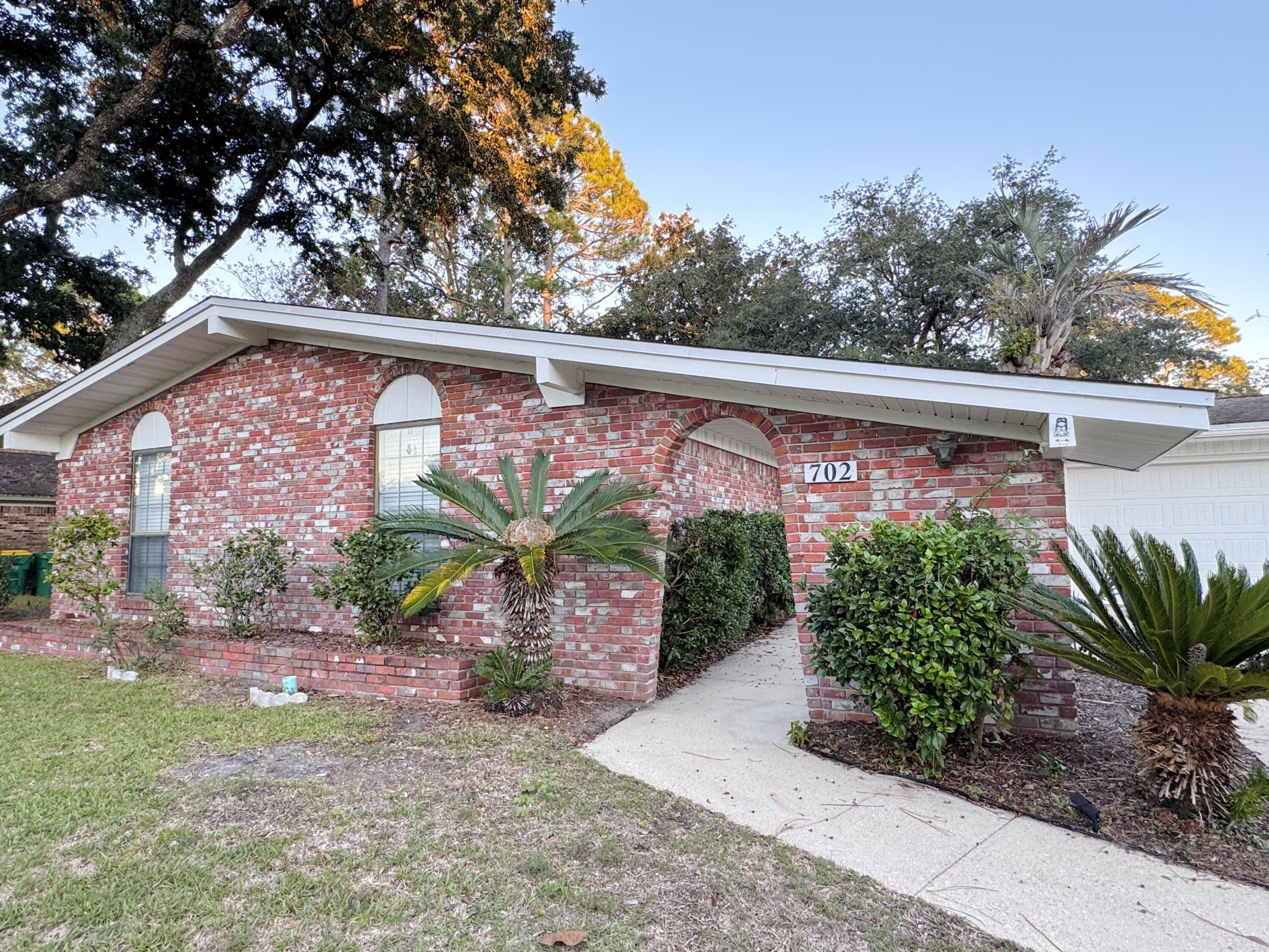 Available 8/25/25! Welcome to this stunning ranch-style brick home in the heart of the beautiful town of Niceville. From the moment you arrive, the charming brick archway welcomes you to your next home. This inviting 3 bed, 2 bathroom property is perfect for hosting large gatherings. The home features a HUGE oversized driveway, 2-car garage, dining area and two living areas, one of them with a beautiful red brick fireplace for a perfect hang out spot, talk about a party! Enjoy a fresh cup of coffee in the morning sitting outside in your peaceful enclosed back porch and fenced in yard. Newly renovated items include upgraded appliances, new flooring, and fixtures. This property sits in a quaint cul-de-sac. Pets allowed with owner approval and $400 non-refundable pet fee.