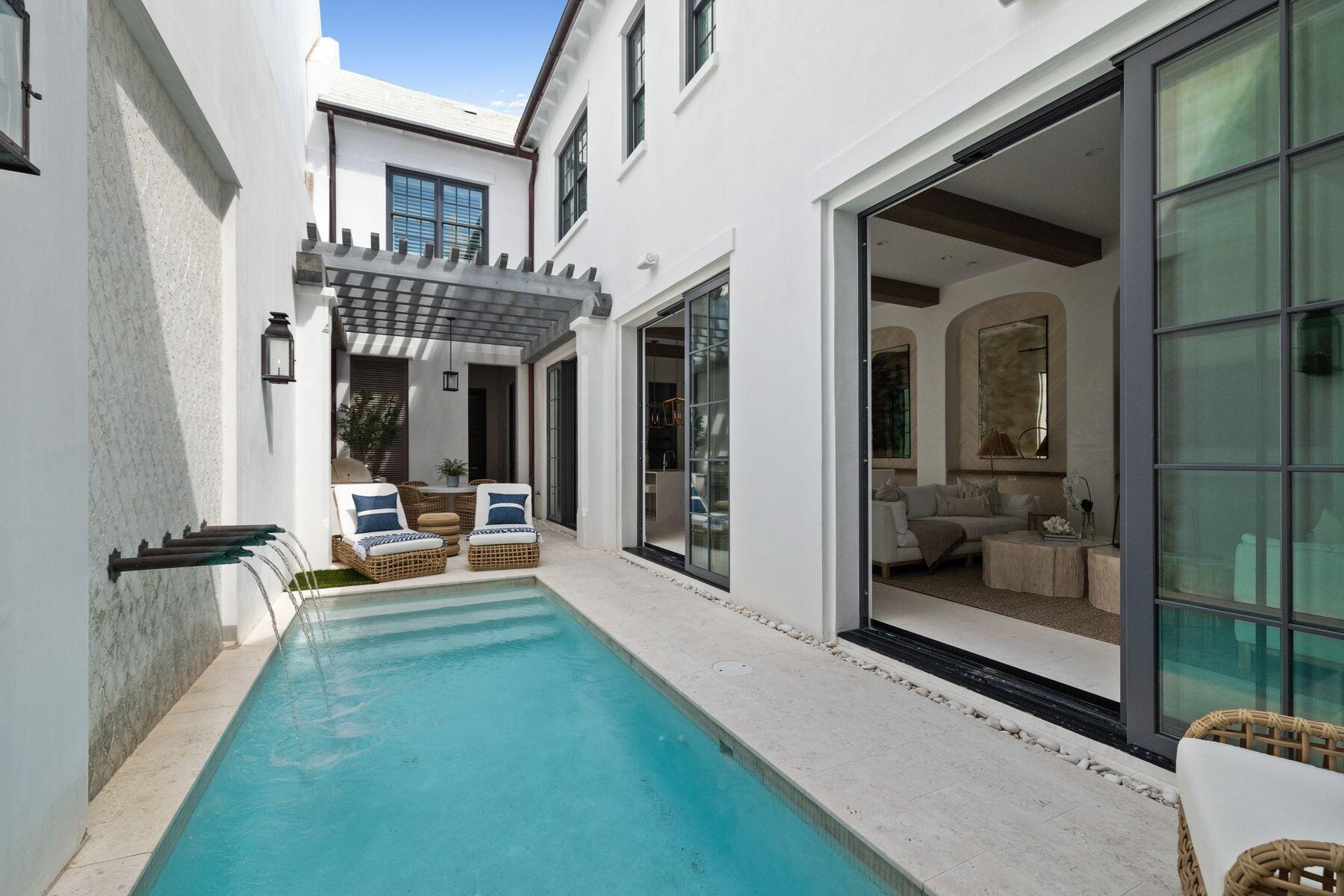 Beautifully designed by Domin Bock Architects, this bespoke property is in sought-after Alys Beach, just a short walk from the beach, shops and town center restaurants. Located on iconic South Charles Street, this luxury townhome has a distinctly Venetian appearance with its second-floor balcony, small-paned windows and dark wood features. The influence continues indoors with rustic beams and Venetian plasterwork. A series of interconnecting rooms deliver multiple indoor and outdoor spaces for relaxing and entertaining in unbridled comfort and luxury. Sliding glass doors connect the open living room with a delightful white-walled courtyard featuring a pool and trickling water feature.