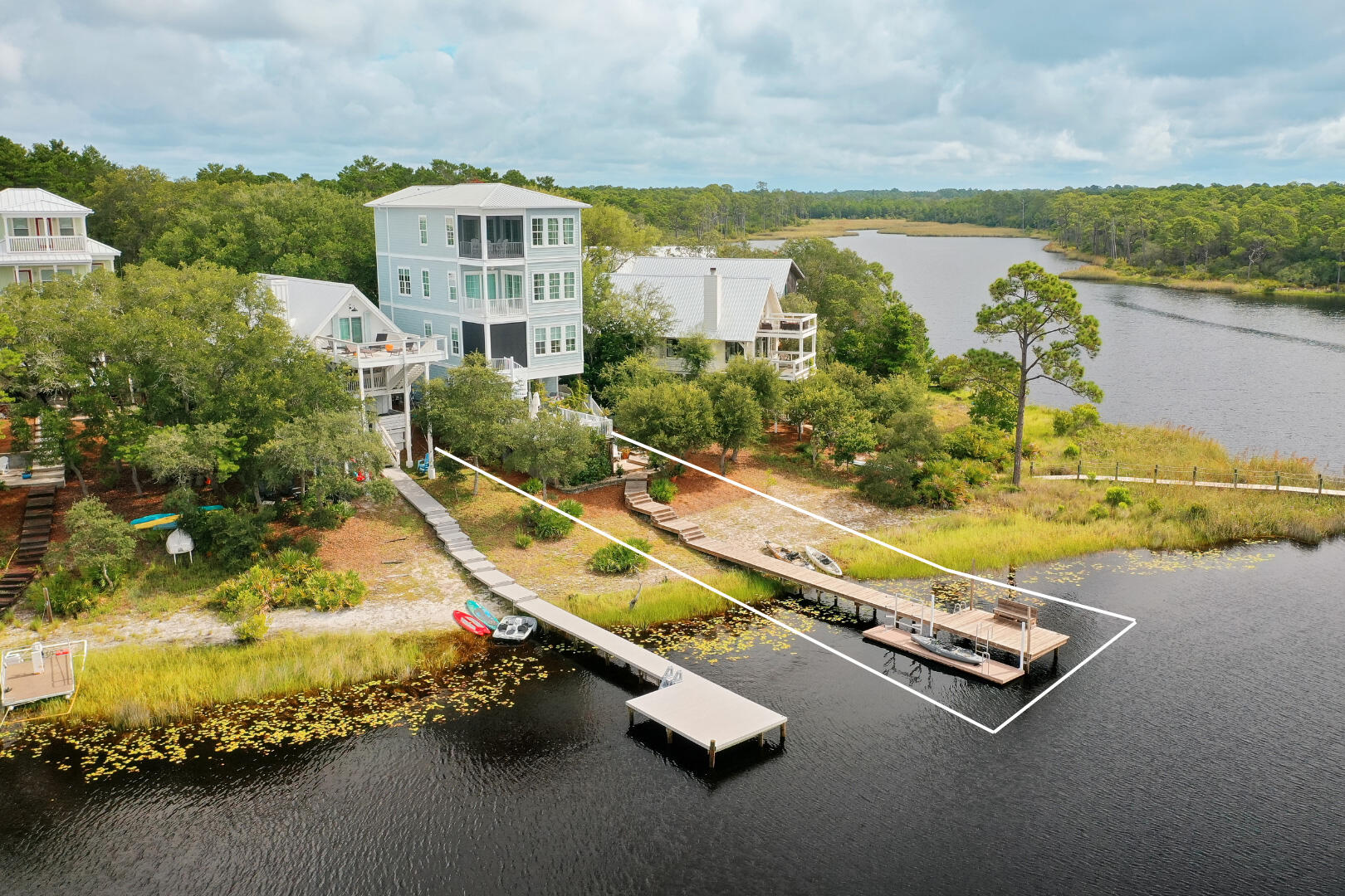 Overlooking the breathtaking panoramic views of Camp Creek Lake and the Gulf, this exceptional water-front retreat provides an unprecedented opportunity to enjoy the perfect blend of lake and beach lifestyle rarely found along the Emerald Coast. This fully-furnished three-bedroom + bunk room, three-and-a-half-bathroom home is designed for effortless coastal living with elevator access to all four floors. Offering seamless access via your private boat dock to Camp Creek Lake that spills directly into the Gulf, you and your guests can enjoy sunsets on the water as well as dockside drinks while making memories as the sun sets over the Gulf. This remarkable home, custom-built in 2019, affords jaw-dropping views from each of its four floors, private balconies, lake-front deck, and private dock. The first floor guest bedroom with en-suite bath offers direct access to the lake-front deck for morning coffee or evening fire-side cocktails under the stars.
Moving upstairs, the second floor features a chef's kitchen equipped with a Wolf range, Sub-Zero fridge/freezer, quartz counters, and an expansive scullery with a second dishwasher and stackable washer/dryer. Just off the kitchen is a powder room, while the open-concept living and dining areas offer a gas fireplace and a private balcony with motorized screens, perfect for year-round indoor-outdoor living as well as a spiral staircase that gives access to the deck below. A cozy seating nook overlooks the water, creating a serene space to relax and take in the views, no matter the weather.
Located on the third floor, the primary suite offers its own seating area just off the bedroom, perfect for morning quiet time as the day breaks. The primary bedroom also has its own screened balcony as well as a large en-suite bathroom complete with a soaking tub, shower, and walk-in closet with an additional stackable washer/dryer.
The third en-suite bedroom is located on the fourth floor which offers a large entertainment/living space, dining area, wet-bar, large storage pantries, and more panoramic views of the lake, dunes, and Gulf from high above the coastline. If a fourth bedroom is desired, this level offers an easy floorpan to accommodate your imagination with ease.
With quick access to shops and dining, easy connections to Watersound Beach Club by boat, kayak, bike, or car, and unmatched views of both the lake and Gulf, this fully furnished, meticulously maintained home offers the rare chance to own a lakefront retreat at the beach with no HOA and the best of both worlds in one exceptional property. Inquire today to start living the coastal lifestyle you deserve.