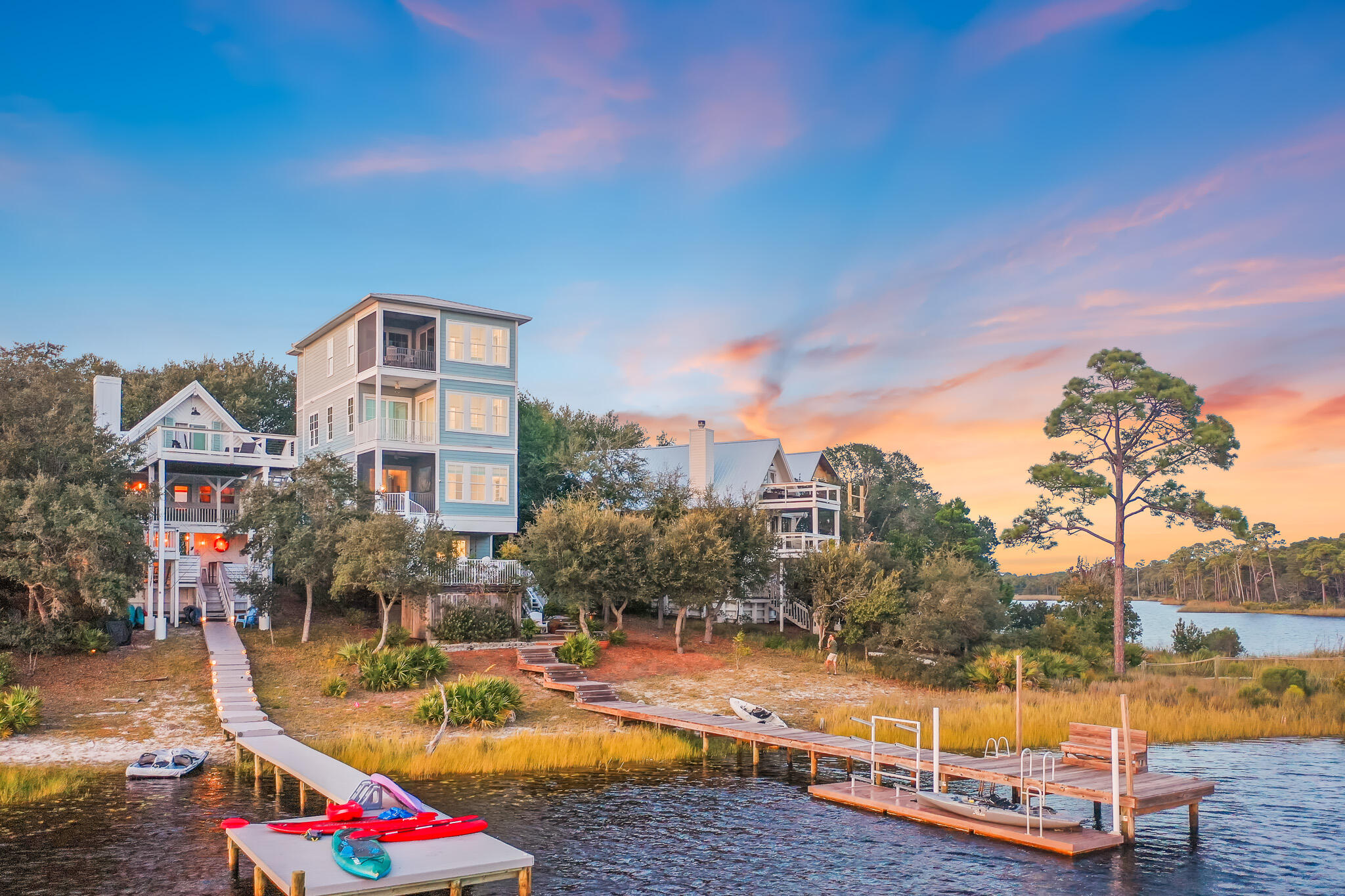 Now offering a $75,000 Watersound Club initiation fee paid with an acceptable offer. Live the lake and beach life all with direct access to the best of Watersound Beach, panoramic views of the lake and the freedom of no HOA. Featuring three bedrooms plus a bunk room, with the option to expand to five total bedrooms, this fully furnished waterfront home offers breathtaking panoramic views of both Camp Creek Lake and the Gulf. From your own private dock, enjoy direct boat or kayak access to the Watersound Beach Club, complete with its private beach and community dock delivering the ultimate blend of lakefront tranquility and Gulfside living. Built in 2019, this custom lakefront retreat combines panoramic views, thoughtful design, and short-term rental flexibility with the rare freedom of no HOA. Wake up to breathtaking sunrises and unwind with spectacular sunsets over the Gulf all from the comfort of a home featuring elevator access to all four floors. Each floor offers its own unique vantage point to one of the most breathtaking water-front properties available. The jaw-dropping views from every floor, balcony, lakefront deck, and a private boat dock deliver a lifestyle and investment opportunity rarely available at this price point.
The first floor guest bedroom with en-suite bath offers direct access to the lake-front deck for morning coffee, afternoon grilling in the summer-kitchen, and evening fire-side cocktails under the stars by the fire.
Moving upstairs, the first thing you will notice are the panoramic lake views as well as Gulf views from your windows with a living room that is flooded with natural light. This second floor features a chef's kitchen equipped with a natural gas Wolf range, Sub-Zero fridge/freezer, quartz countertops, and an expansive scullery with a second dishwasher and stackable washer/dryer. Just off the kitchen is a powder room, while the open-concept living and dining areas offer a gas fireplace and a private balcony with motorized screens, perfect for year-round indoor-outdoor enjoyment as well as a spiral staircase that gives access to the deck below. Back indoors, a seating area overlooks the water, creating a serene space to relax and take in the views, no matter the weather.
Located on the third floor, the primary suite with impeccable Gulf views offers its own seating area just off the bedroom, perfect for morning quiet time as the day breaks. The primary bedroom also has its own screened balcony as well as a large en-suite bathroom complete with a soaking tub, shower, and oversized walk-in closet with an additional stackable washer/dryer, and custom cabinetry/storage space.
The third en-suite bedroom and dedicated bunk room are located on the fourth floor which offers a large entertainment/living space, dining area, wet-bar, two storage pantries, and more panoramic views of the lake, dunes, and Gulf from high above the coastline. If an additional bedroom is desired, this level offers an easy floorpan to accommodate your imagination with ease.
Back on the first floor, the garage, currently used as an art studio, is fully equipped with plumbing and electricity to convert to a fifth bedroom if so desired.
With quick access to shops and dining, easy connections to Watersound Beach Club by water or road, your club initiation fee paid for by the seller, and unmatched views of both the lake and Gulf, this fully furnished, meticulously maintained, and never rented home offers the rare chance to own a lakefront retreat at the beach with no HOA. The best of both worlds all in one exceptional property. Inquire today to start living the coastal lifestyle you deserve.