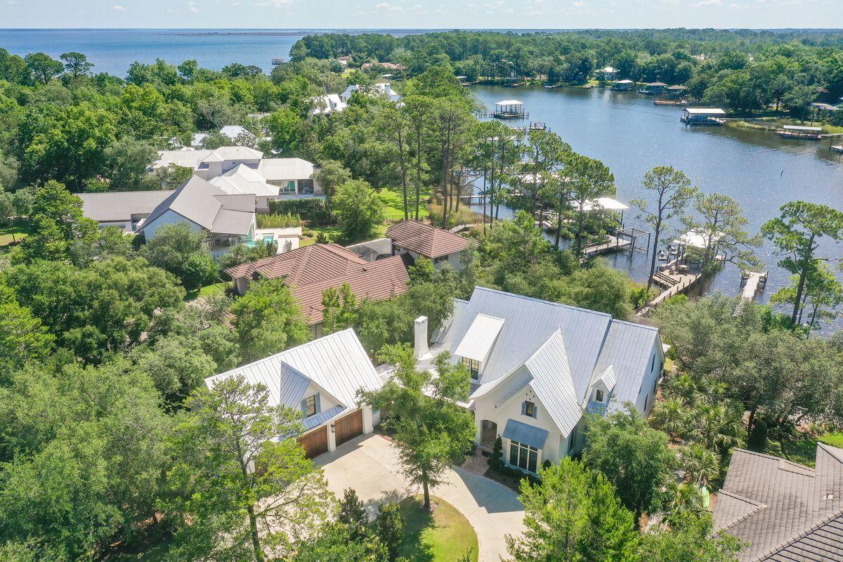 This amazing home in the gated community of Botany Bayou has everything you'll need for a full-time residence or vacation home on the bayou! This custom home has 75 feet of bayou frontage with a custom, covered dock that includes a boat lift with boat and two jet ski lifts with jet skis. The first floor has a master suite, a guest bedoom, living room and separate living area with attached screened porch and outdoor fireplace. The family room, dining area and kitchen are open and perfect for entertaining or family get togethers. The kitchen has Sub-zero and Wolf appliances as does the Butler's Pantry.  The master suite on the back of the home has views of the bayou through a screened porch and hot tub. There are two walk-in closets, marble shower and soaking tub.