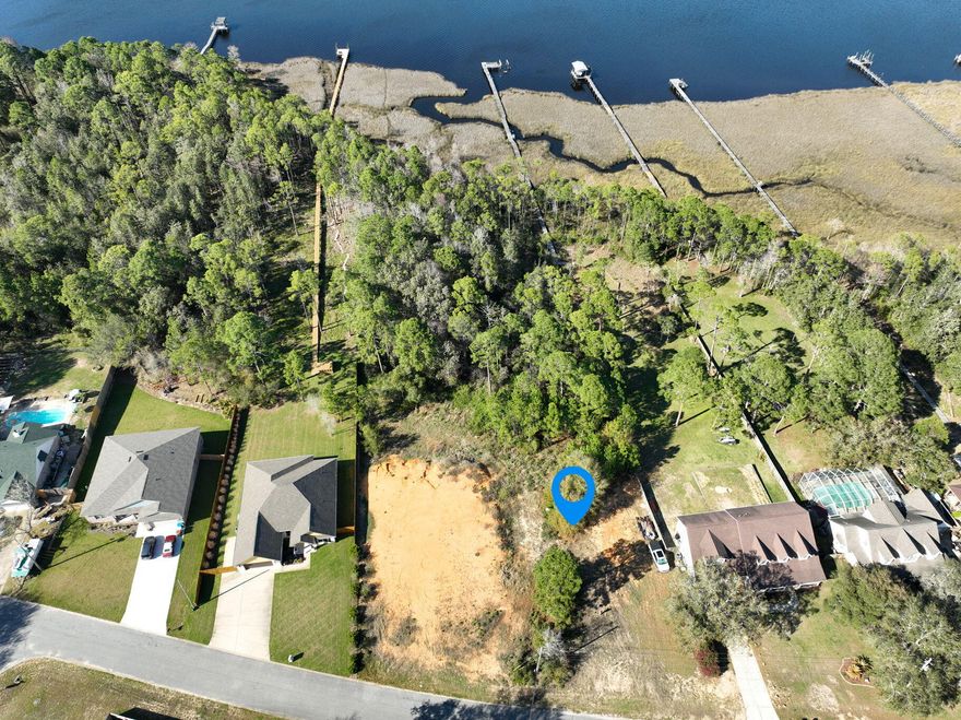 Your Dream Waterfront Property Awaits on Sleepy Bay Blvd. Discover the ideal setting for your coastal retreat with this remarkable 1.66-acre residential parcel in Navarre, FL. Offering direct waterfront access to East Bay, this property provides the perfect blend of peaceful surroundings and endless possibilities for your future home. With over one and a half acres of natural beauty, the property offers ample space to design your dream home, complete with outdoor areas to soak in the bay's tranquil views. Whether you're envisioning serene mornings with the sunrise, evening sunsets spent gazing at the water, or lively gatherings with family and friends, this parcel delivers an unparalleled lifestyle. Beyond your future home, Navarre shines as a destination for those seeking both relaxation and adventure. Navarre Beach offers some of the most stunning white sands and crystal-clear waters on Florida's Emerald Coast. Water enthusiasts enjoy kayaking, paddleboarding, boating, and world-class fishing. The area is also known for its vibrant culinary scene, featuring an array of dining options, and offers excellent shopping opportunities from unique boutiques to modern retail centers. This property isn't just landit's a gateway to the coastal lifestyle you've always dreamed of. Build your future on Sleepy Bay Boulevard and take the first step toward making your vision a reality. A Wetlands Delineation Report has been completed and is available.