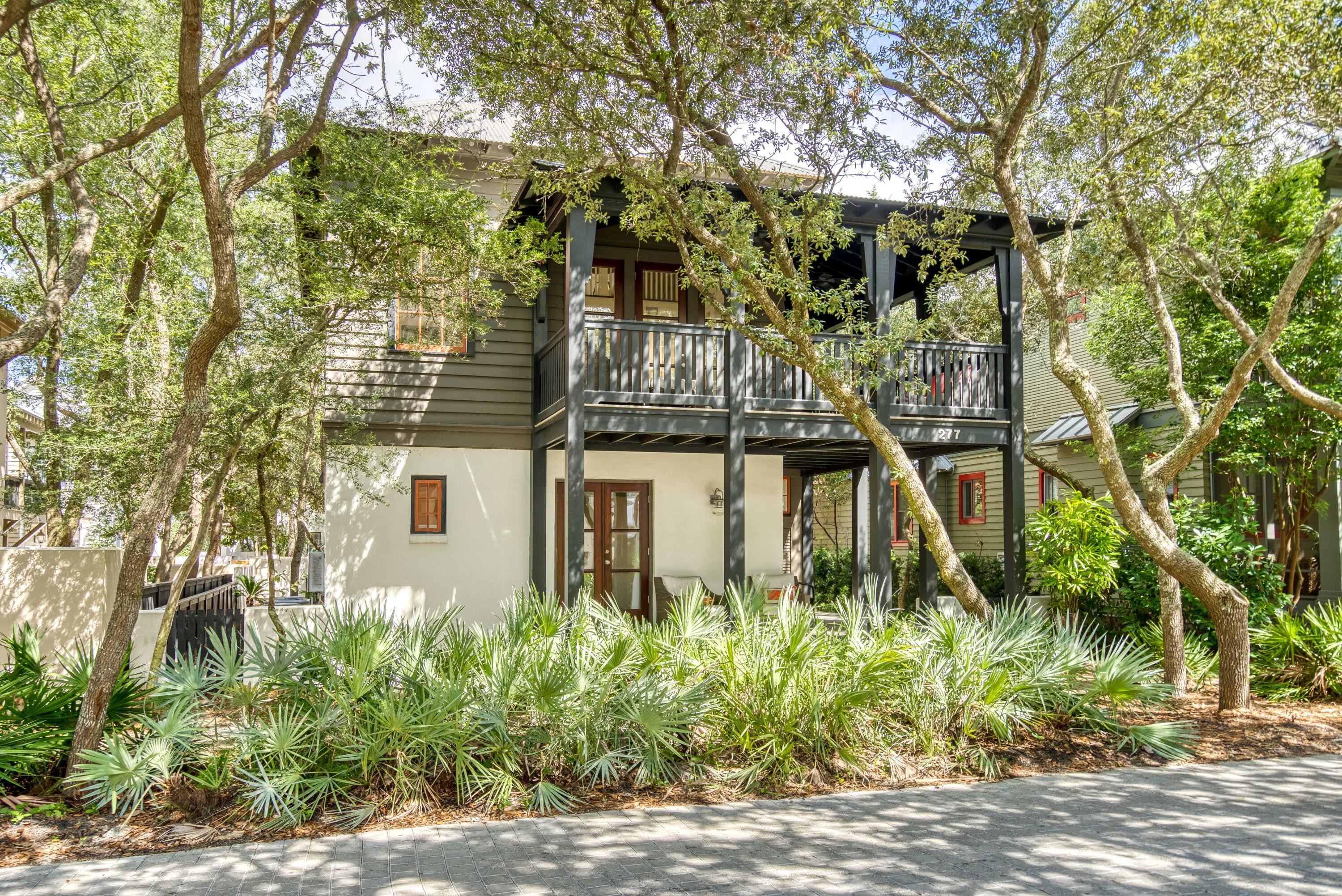 Tucked away on E Water St. in Rosemary Beach this 3-bed, 2.5-bath cottage is a charming 2-story family retreat just 2 blocks from the Gulf. Drawn by famed architect Eric Watson in the original West Indies design, the exterior matches the style of a classic Rosemary Beach home. Enter the foyer through the covered front porch on the ground level, which leads to the master suite and two additional bedrooms. Head upstairs to the second floor into the open format kitchen and dining room, complete with high vaulted ceilings, hardwood floors, updated appliances, and an island with seating for three. Pass through the to the roomy living room with multiple high windows that bring in ample natural light, as well as direct access to the cozy wrap-around corner balcony that elicits the atmosphere of