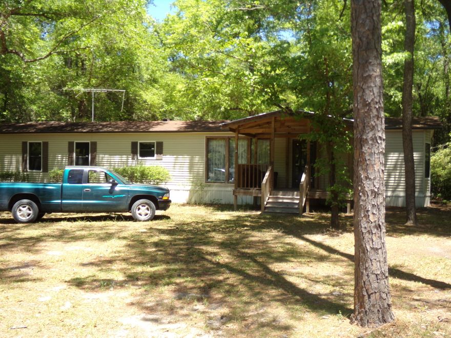8.37 acres on paved road with an 1987 single wide mobile home that is being sold in current condition, AS IS~ There is a large detached garage, with power~ There is a shop and a couple of other buildings as well for storage~ Beautiful trees and level~ Would make a beautiful place to build your dream home~