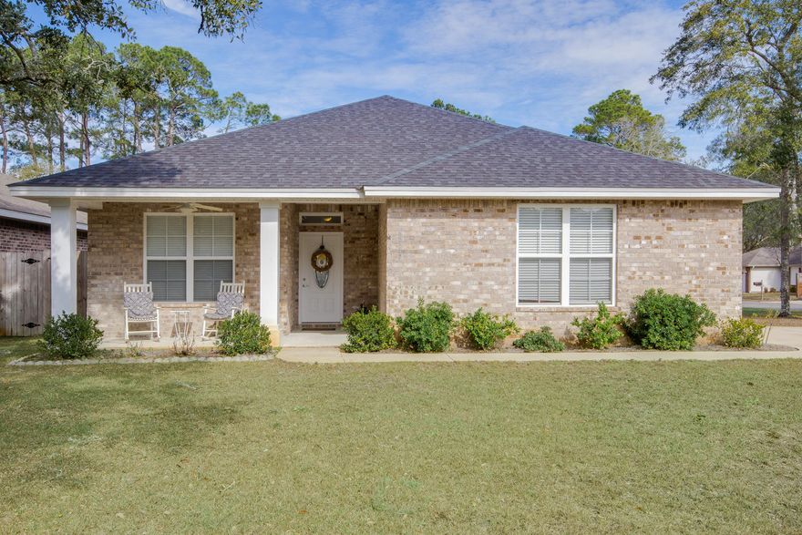 Open concept four-bedroom home in Niceville! As you walk up to the front door, a covered front porch welcomes you into this 2012 home. As you enter, you notice the beautiful wood floors flowing through the foyer, living room, kitchen, and bedrooms. This home features two master suites, perfect for you and your guests. Painted in a beautiful neutral gray and featuring bright white crown molding, this home is truly move-in ready. The bedroom suite with full bath is off the front entrance. The foyer opens into the living room, dining area, and kitchen. The kitchen has a large wrap around bar and island with pendant lighting, lots of cabinet space, granite counter tops, on-trend tile backsplash, pantry, and stainless steel appliances. From the kitchen and living room you can see out to the