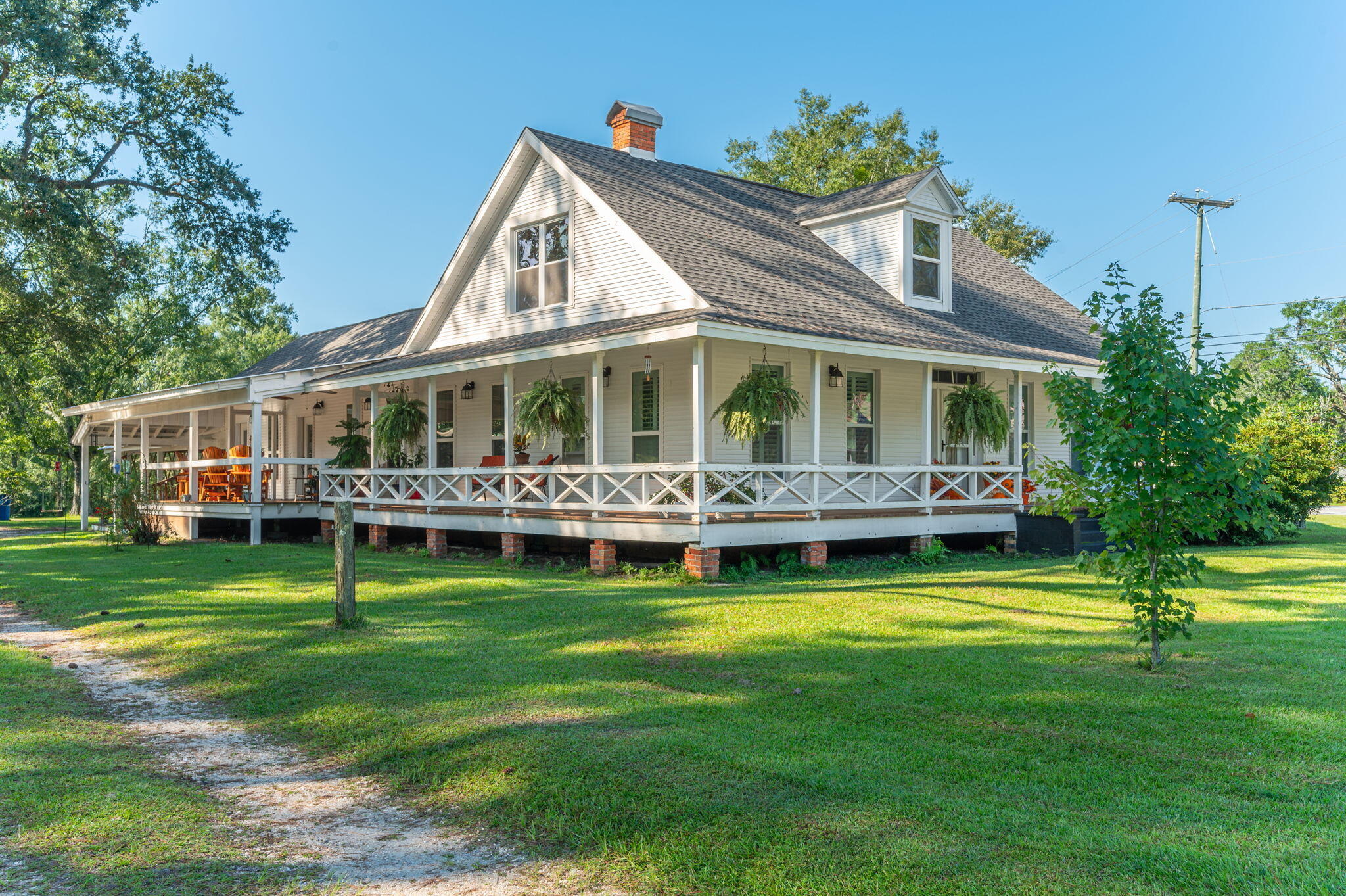 Exquisite Commercial Property with Endless Possibilities! This exceptional estate offers nearly 2.5  acres with prominent highway frontage, making it the perfect setting for a chic Bed & Breakfast or an upmarket antique store/clothing boutique.Graceful Southern Living style covered porches extend from the front and rear of the residence. Inside, you'll find expansive rooms, gleaming hardwood floors, tasteful cased windows, plantation shutters, and multiple fireplace mantles. The residence itself exudes warmth and sophistication.Enjoy the beautiful in-ground swimming pool, carport, and workshop on the spacious lot, complete with mature hardwoods. An unparalleled investment opportunity!