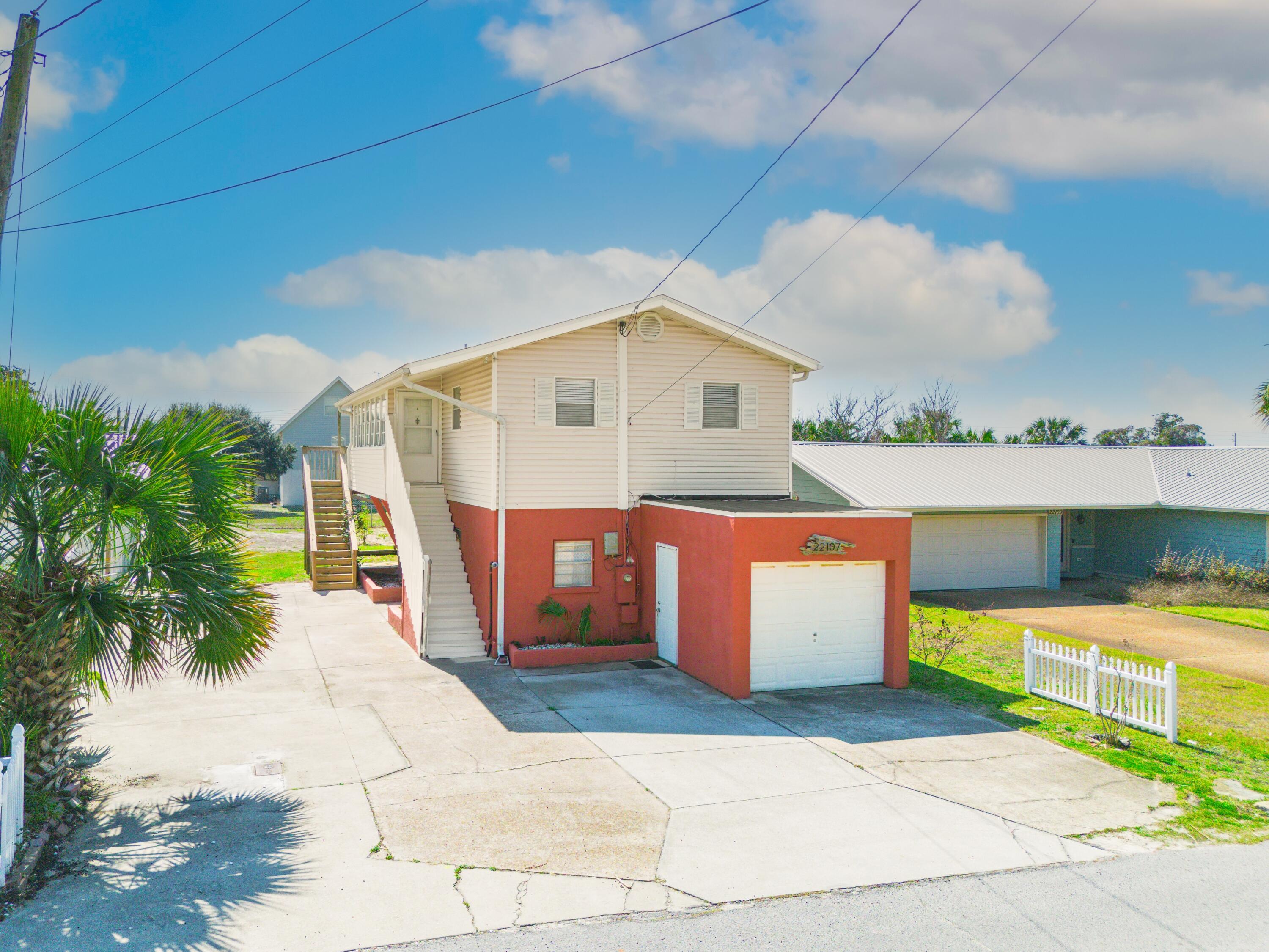 What a great find and A GREAT NEW PRICE!!! This ''Old Florida'' beach house on the West End is what you've been searching for. Just two short blocks from the public access and the white-sand beaches, this home makes a perfect vacation home or rental opportunity. The home sits on a huge lot with plenty of room for a pool, carriage house or any other backyard fun recreational items your heart desires. In addition, the house can be used as a single-family home or a duplex! Downstairs has a kitchen, living room and dining area as well as 2 bedrooms and a bath. Upstairs has a kitchen, living room, dining area, primary bedroom, and bath. Just off the living area is a great sunroom and huge balcony with peeping Gulf views! The balcony offers a comfortable place to relax and see gorgeous sunsets and it's large enough for all your friends to enjoy with you! Other perks to this great beach house are a golf cart garage, laundry room, large storage room, and an outside shower. Plenty of parking space on the expanded driveway, a large backyard for any new additions you might have in mind, the opportunity for a personal home or use as a Duplex for rental income, and less than 1,200 feet from the sugar-white sands of the beach. Better take a look at this one!!!