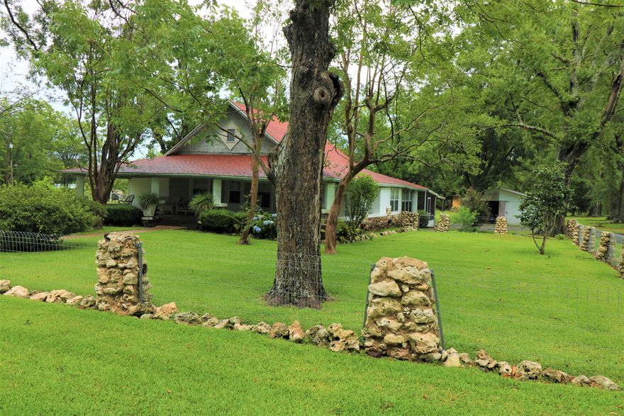 One of the rarest finds in the city to have this much acreage. Such a gorgeous historical home with stone trim all around to match the stone pillared fence. The landscaping is lush, mature, and well maintained. Grand wrap around porch greets you with tons of space. Enter to find a lovely kitchen with windows all along the back of the home for your viewing pleasure. Primary bedroom has a walk-in closet, wall of windows, and full bath. There are 3 yard buildings on the property allowing for plenty of work space and storage. Additional features include an eat-in kitchen, screened in porch, attached carport, heated and cooled sun-room, cool bonus room, large laundry room, newer windows, updated electrical, and great water pressure! Termite bond transfers to new owner.
