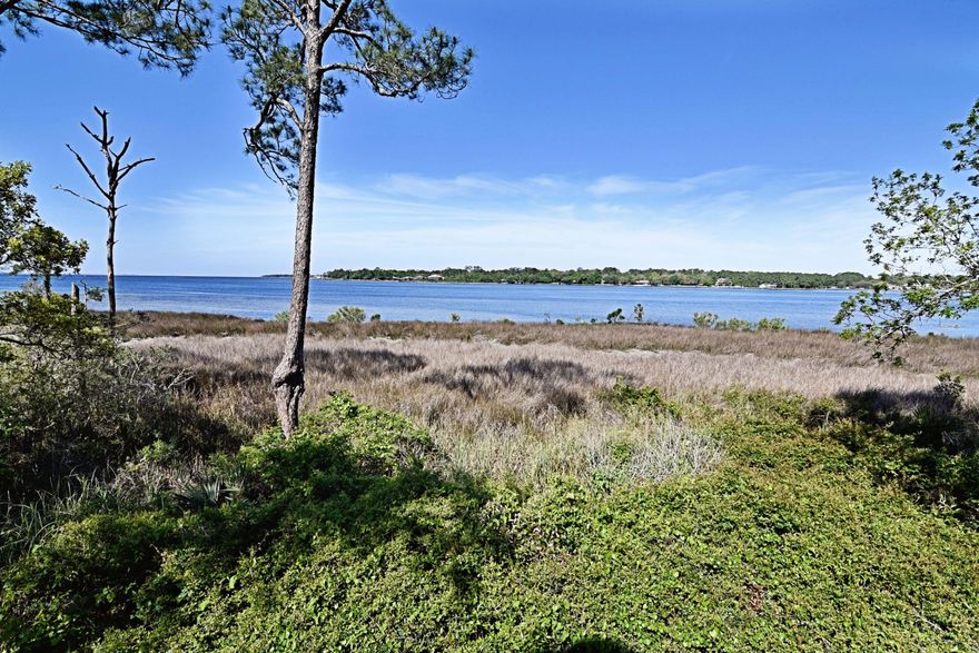 Great 3/4 story, 3bed/2.5bath, 1,833 sq/ft townhome in Bluewater Bay's Marina Cove Village and only 50 yards from LJ Schooners Dockide Restaurant w/ great views of the bay from every floor. Home includes 2 open balconies, 1 open-deck and 1 screened-in back patio-room; These are great for watching the sunset as they are Westerly facing. Entry leads onto living area w/ wood-burning fireplace, vaulted ceiling, half-bath and sliding glass doors to balcony/deck space w/ stairs down to yard area. Next level includes large kitchen w/ indoor laundry area, dining space, screened-in back patio-room, and open-deck on front. Stairs lead to 1st additional bedroom and windowed nook w/ railing looking down upon the living area.