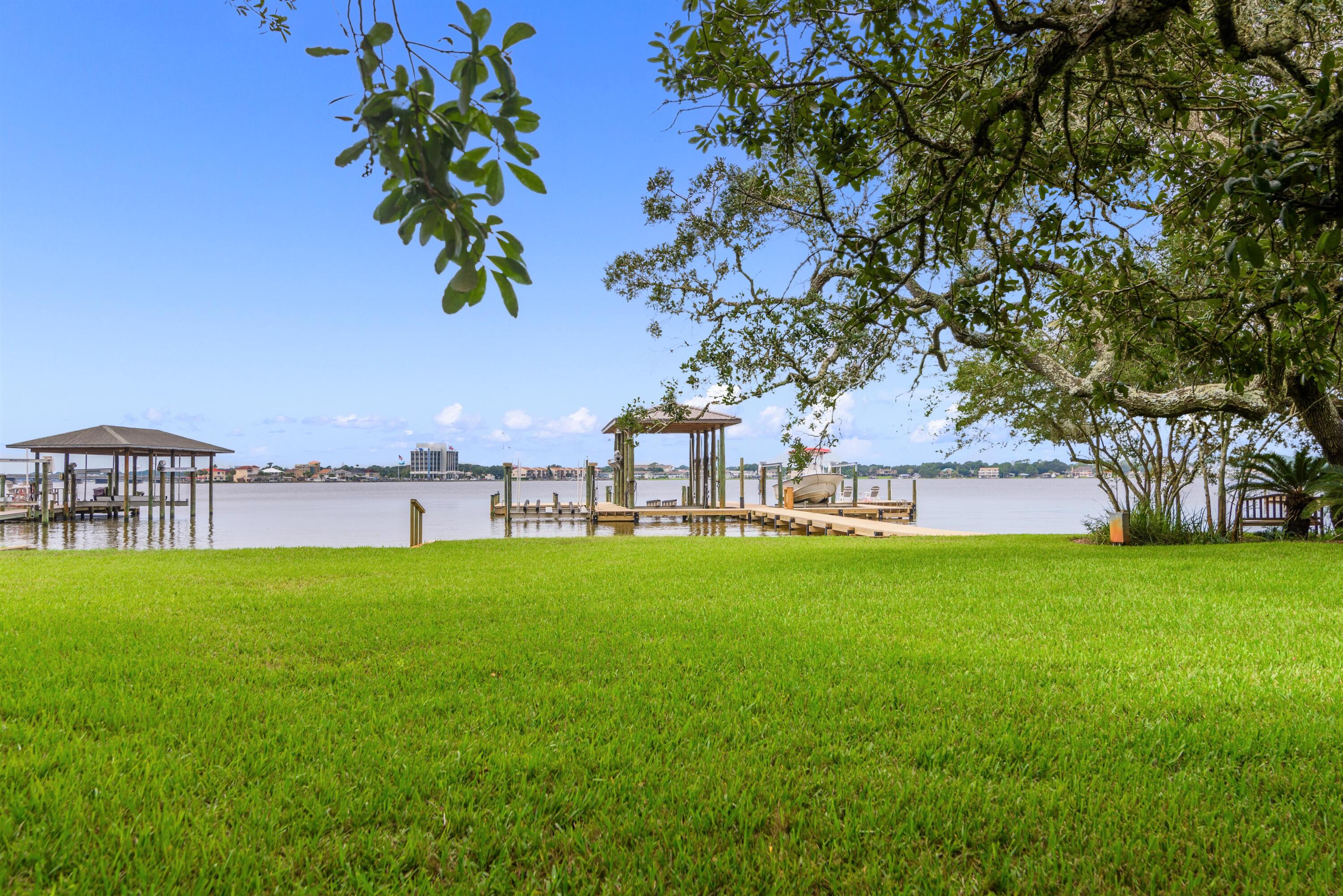FABULOUS waterfront home on DEEP water, .55 acre lot/95' on Garnier's Bayou in the prestigious Shalimar Plantation. A vaulted foyer welcomes you with a custom ceiling & impressive stairway leading to the 2ndlevel.  As you walk into the family room, the clear sight lines running out to the bayou will delight you.  Master suite is on the 1st floor and has all the comforts of a spa.  Floor plan ensures EVERY bedroom has fantastic water views. French doors lead out to the patio & the outdoor kitchen/gazebo.  Gaze further out across the private back yard to your dock and boat lifts! Two lifts. Yes, this home has a  boat house w/a large lift and another lift configured at present for 2 jet skis.  Dock decking is the expensive perforated composite decking. The ultimate waterfront home!  WOW