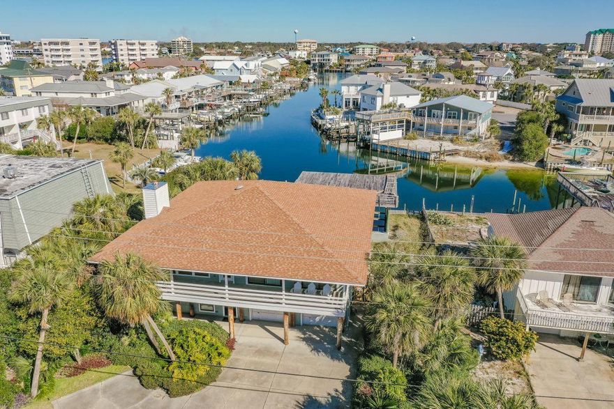 Enjoy the waterfront lifestyle with two spacious covered deepwater boat slips and ample docks spaces. Home is located on canal that leads you to Crab Island, East Pass and the Gulf of Mexico.A boater or beach lover's paradise, this home is located on the corner of the canal on Holiday Isle and features serene water views. With a first level that can be utilized as a lockout with its own private exterior access, the second level features open living spaces and large covered porches. An oversized garage provides plenty of space for storage and parking. Wake up to water views, with the canal visible from the large pool area and the Gulf of Mexico visible from the second floor balcony. The home includes two covered boat slips, two additional dock spaces, and deeded beach access.