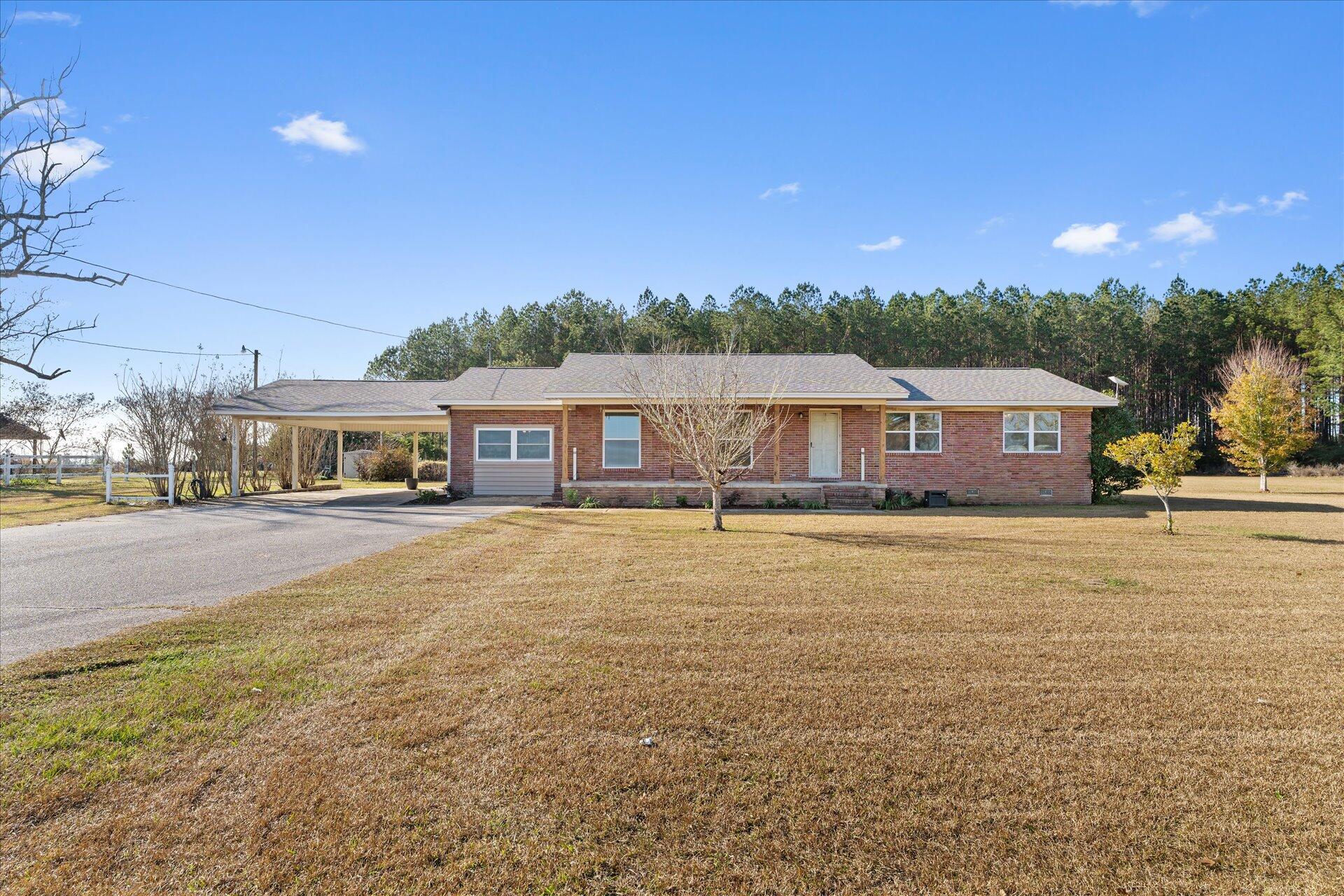 Welcome to this beautifully remodeled 4-bedroom, 3-bathroom home, perfectly situated on over 2 acres of land. This property offers the perfect blend of modern updates and tranquil country living, providing plenty of space both indoors and outdoors. Step inside and be greeted by a semi open-concept floor plan that's filled with natural light and modern finishes. The spacious living area, which was previously used as a master suite, includes a full bathroom, gleaming plank floors, a cozy fireplace, and large patio windows to take in the surrounding landscape. This versatile space offers countless possibilities to fit your lifestyle needs. An added bonus room, offering incredible flexibility for use as a playroom, home gym, craft room, office or even a private home theater. The choice is yours! The amazing renovated kitchen is a chef's dream, boasting sleek granite countertops, stainless steel appliances, a large island, and plenty of cabinet space for storage. The primary bedroom is complete with an en-suite updated bathroom. Three additional well-sized bedrooms offer ample space for family, guests, or a home office. This home is also equipped with a state-of-the art solar power system and 2 TESLA powerwalls, providing energy efficiency and reliability while reducing your environmental impact. Enjoy the benefits of lower utility costs and peace of mind during power outages. Outside, the 2-acre lot provides endless possibilities. Whether you're enjoying the expansive yard, the large 48'x30' powered shop, gardening, or entertaining on the patio, this property offers the perfect outdoor sanctuary. The ample land also provides room for future additions, such as a pool. Located near Whiting Field, beaches, and local amenities, this home offers the perfect balance of privacy and convenience. Don't miss the opportunity to make this stunning remodeled home your own!