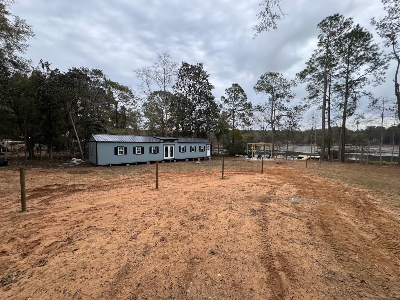 Beautiful lakefront lot with new, custom 900 sqft lake house shell. House has insulated windows and doors with superior views of the lake. Architect design provided for interior completion and has already been approved by the Planning Department and fees paid. Septic tank has also been approved and permitted and will need to be installed. Property is entirely fenced with a large gate and lock for security. Also recently added is the wood gazebo and fire pit perfect for stargazing and roasting marshmellows with friends and family. The best part of this lakefront getaway is definitely the newly built dock where you'll spend most of your time feeding the turtles, fishing, sunbathing and so much more. Set up your showing soon, this piece of paradise won't last long!