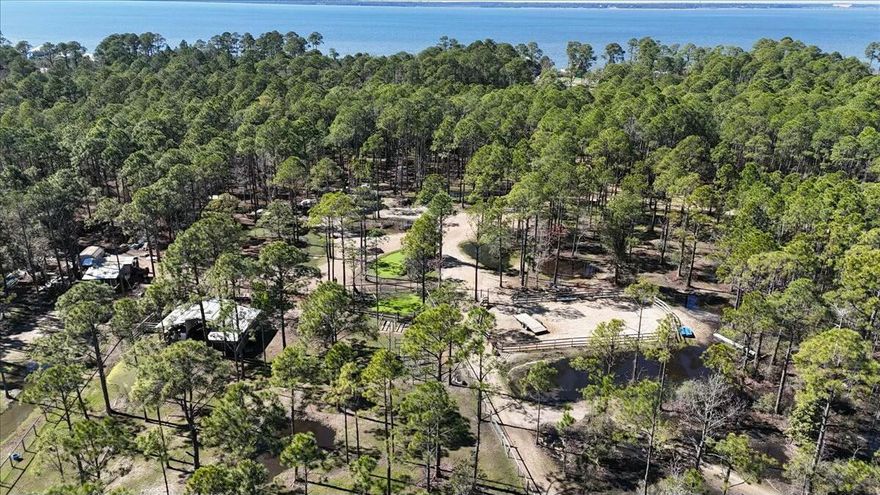 This property has been home to The War Horse Project, a not-for-profit for veterans, adults, and children in equine therapy. All acreage is fenced and cross-fenced. This property is home to free-roaming horses, cows, donkeys, goats, pigs, ducks, and chickens. There are many trails for riding, small ponds, and three riding arenas. Located only 15 minutes from Pensacola International Airport and 10 minutes from Gulf Breeze. It is located on a dead-end street with lots of privacy, yet it is convenient for everything. The property has a ''tiny house'' that works well as an office or rental on Airbnb. Two property entrances are gated. Beautiful and peaceful getaway! For more photos and drone footage, please visit 902clearview.com