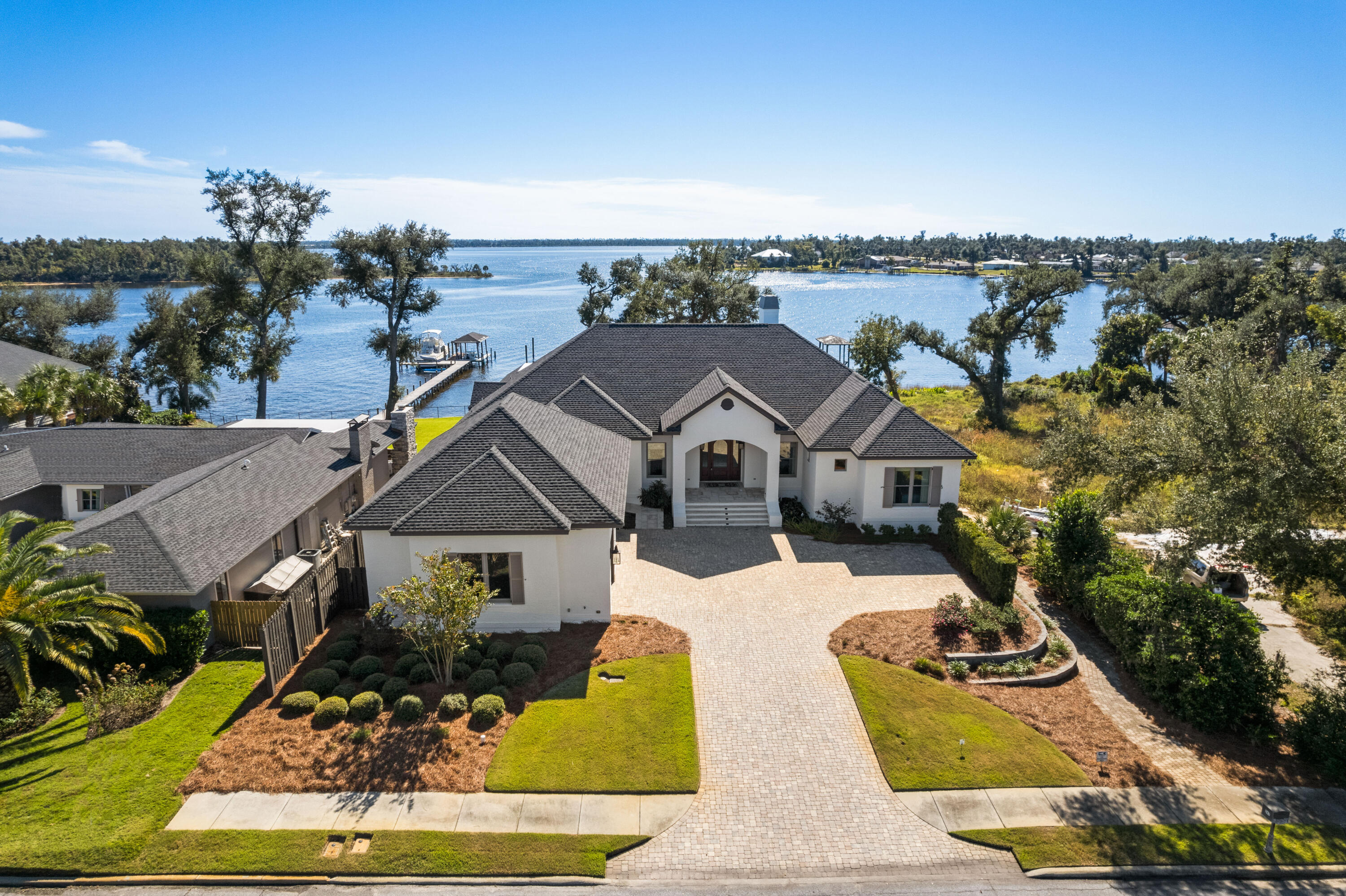 This modern, transitional waterfront masterpiece 6,700 SF residence takes full advantage of its bayfront location, blurring the lines between indoors and out while allowing for the most pleasurable resort-like lifestyle. The breezy outdoor spaces and light-filled, view-focused interiors offer relaxed and refined modern living. With over 100 feet of water frontage on St. Andrews Bay, this home boasts a private boat lift, boat house and dock leading from the water to the estate's lavish amenities which include a pool, hot tub, screened-in outdoor kitchen, pool, hot tub and accordion doors that lead to an exceptional family room and wet bar.