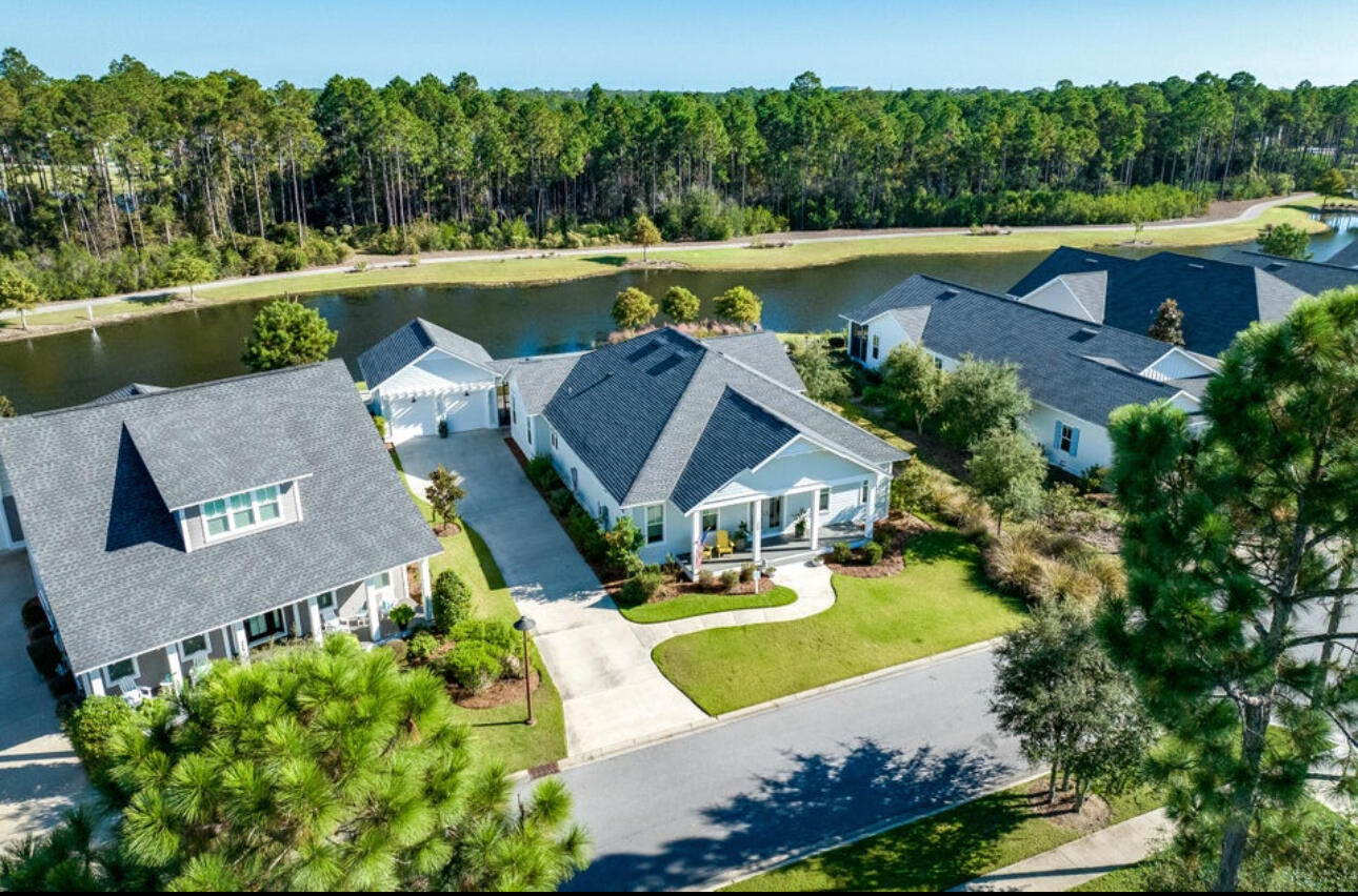 Most SERENE setting! This stunning residence is nestled in the highly sought-after PATHWAYS phase of Watersound Origins and is strategically positioned across from a charming courtyard and offers an enchanting pond view in the back; presenting an exceptional homesite opportunity.Crafted by Huff Homes, this upgraded and revised Ficus plan showcases meticulous attention to detail With 4 bedrooms, ample closet space, and 3.5 bathrooms, the home is thoughtfully designed for both comfort and luxury. The rear load 2-car garage is conveniently attached to the screened-in porch at the rear of the property. Upon entering through the double door entry, you'll be captivated by the high-end features that define this residence. Revel in the 10' ceilings, elegant Quartz C countertops throughout, medallion wood flooring, 8' solid core doors, crown molding, and the inviting warmth of an interior gas fireplace. The kitchen is a chef's dream, featuring upgraded WOLF appliances, including a Dual Fuel 30'' Range and vent hood, a SubZero Refrigerator with a bottom drawer, and a 24'' microwave drawer.
The coastal charm of this home is further enhanced by shiplap detailing that graces the walls throughout. The open concept kitchen seamlessly flows into the living spaces, creating an ideal setting for both everyday living and entertaining.
Step onto the expansive rear screened porch and be greeted by breathtaking views of the pond, a walking path, and a wooded Preserve beyond. The fenced backyard provides ample space for delightful gatherings and offers the potential to transform into a personal oasis, complete with a custom pool, spa, outdoor cabana, and fireplace.
This residence at 239 Sandchase Circle epitomizes the timeless allure of coastal living, offering a perfect blend of sophistication, functionality, and natural beauty. Don't miss the opportunity to make this exceptional property your home.