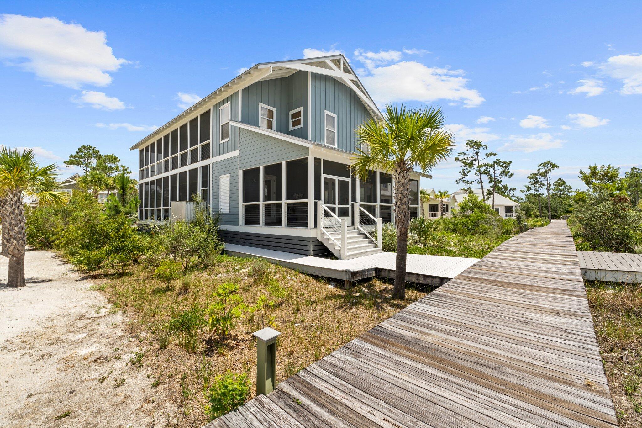 Enjoy Bay views from this beautifully built custom home in Windmark Beach. Featuring ICF construction, Hardie board siding, and metal roof. This home is decked out with upgrades including hardwood flooring throughout, custom lighting & fixtures, stainless steel appliances, and a gas range. The living room & kitchen are perfect for entertaining Enjoy the beamed ceiling & huge island w/ custom cabinetry. Flow right out to the screened in porch to continue the relaxation. The bedrooms feature vaulted ceilings, private porches, custom bunk beds and multiple bathrooms with double vanities along with custom tilework throughout and stand-up showers. All that beauty just to step outside to even more peace & tranquility of Windmark Beach featuring beach access, shopping, water access, etc. The spacious screened-in porch is ideal for grilling, dining, and enjoying the breeze. The main level includes a comfortable guest suite and a conveniently located laundry area. Upstairs, the primary suite is a true retreat, with vaulted ceilings, shiplap accents, and a private screened porch perfect for morning coffee or evening relaxation. A second bedroom suite and a versatile loft/living space create a great hangout area for teens or guests, along with a built-in bunk room that sleeps four and shares a beautifully designed hall bath. This home is fully furnished, rental ready, and already income producing. Built with ICF construction, it offers excellent insulation and strength an instant equity advantage over traditional wood framing. WindMark Beach offers resort-style amenities including a community pool, playground, nature trails, boat docks, and deeded beach access to sugar-white sand. Hop on your golf cart to explore nearby dining, boutique shops, and the fitness center. Whether you're looking for a vacation retreat, full-time residence, or an investment opportunity, this home checks every box.