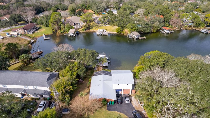 100' waterfront on Cinco Bay with a covered dock and boat lift. This 4 Bedroom 2.5 Bath house has been updated inside and out. New metal roof was installed 2020. The Kitchen has been updated with new cabinets, granite countertops, black appliances to include a oversized gas stove top. Tile and stone flooring throughout. The master bedroom is on the second floor with its own private balcony overlooking the water. The master has a large walk in closet, and the master bath has been updated with newer cherry wood cabinets with a double vanity and Blue Pearl Granite, large walk in shower with 2 shower heads. The full bath downstairs was fully remodeled with a new bath tub, tile flooring, vanity and lighting. All 3 guest bedrooms are downstairs.  Seller is including the Hot Tub located on the