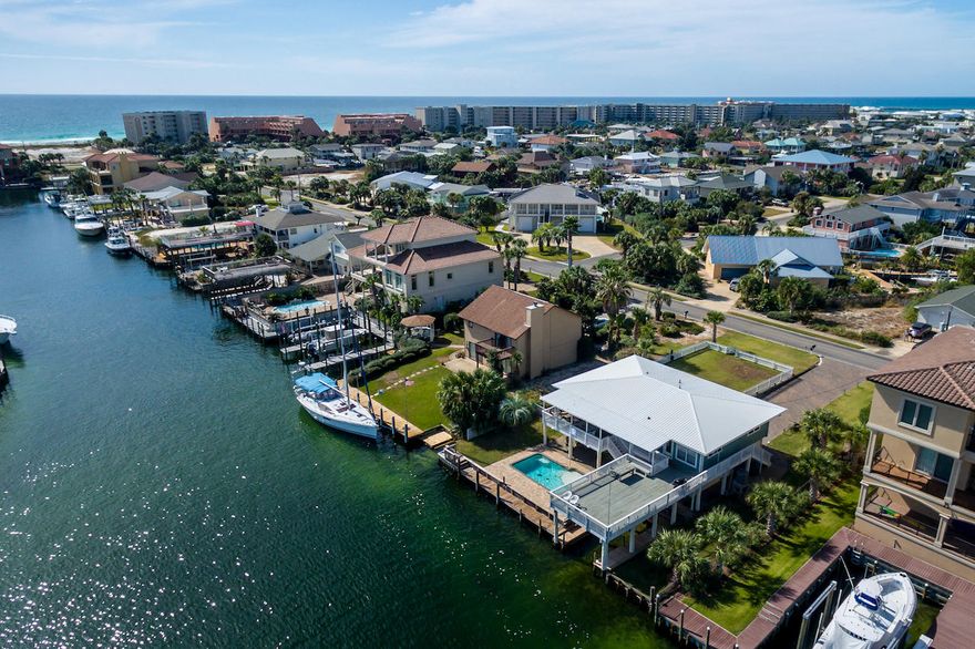 Rare opportunity to own a vacation rental machine on Holiday Isle! This lovely home was purchased by the current owners as their permanent residence until the military transferred them to California  and has been a consistent vacation rental income producer since then. The owners transformed this 45-year old classic beach house located on the canal (very close to the Harbor) into the lovely, updated home it is today. They installed a new kitchen with stainless steel appliances, granite and backsplash in 2011. They installed a brand new custom in-ground gunite, heated pool in 2013 (with a convenient outdoor shower). The covered boat slip has a working lift, new decking along the sea wall, and they reinforced the supports for the deck above the boat slip with new dock pilings.