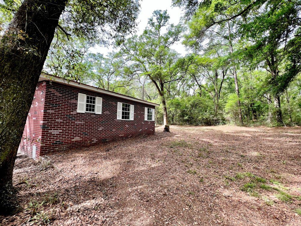 REDUCED! Home in peaceful setting with elbow room on 2 acres. Detached garage is 33x23 and has new roll up door with plenty of space for workshop. The home has stucco exterior which looks like red bricks. Roof is red metal. Home has been recently completely renovated. Upgrades include new floor covering, new countertops refinished sheetrock, paint, brand new HVAC and duct work replaced, refinished kitchen cabinets.. Relax and enjoy the Hot tub just off the master bedroom. Kitchen has plenty of cabinet and counter space. Stove, fridge,microwave, stackable washer/dryer stay. Large covered deck at side entrance with swing. Lots of large oaks in yard,