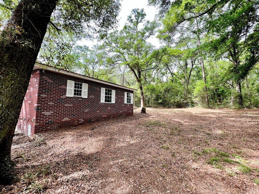 REDUCED! Home in peaceful setting with elbow room on 2 acres. Detached garage is 33x23 and has new roll up door with plenty of space for workshop. The home has stucco exterior which looks like red bricks. Roof is red metal. Home has been recently completely renovated. Upgrades include new floor covering, new countertops refinished sheetrock, paint, brand new  HVAC and duct work replaced, refinished kitchen cabinets.. Relax and enjoy the Hot tub just off the master bedroom. Kitchen has plenty of cabinet and counter space. Stove, fridge,microwave, stackable washer/dryer stay.  Large covered deck at side entrance with swing. Lots of large oaks in yard,