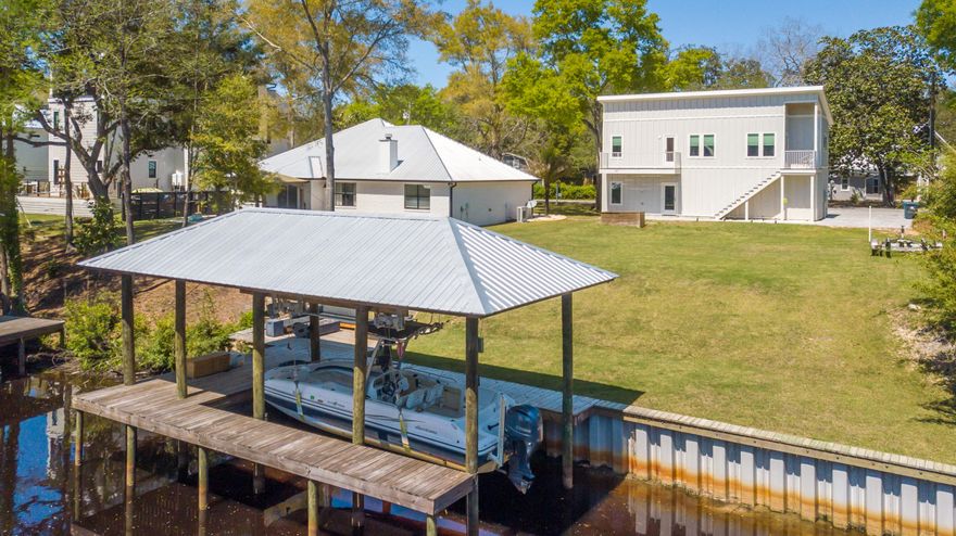 This Point Washington homes sits on a canal that has access to the bay! A beautiful southern facing lot that has a 800sf carriage house with a 2 car garage already built so you can live in while you design and build the main house then carriage house has it's own rental potential.  It already has a seawall, dock with boat lift, and deck built. It also sits across from a landscaped vacant lot and its fairly wide at this part of the canal as well. The carriage house has wood scooped ceilings and hardwood floor.