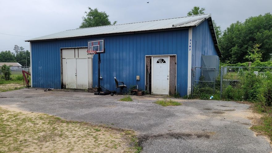 Huge workshop on half acre lot! Workshop has to garage doors. Mobile home is in as is condition. Workshop has office and bathroom and also is fully fenced and gated! Two double bay overhead garage doors allow for you to use this as a commercial property! It was used at one point as a business. Come see what you can do with this incredible property!