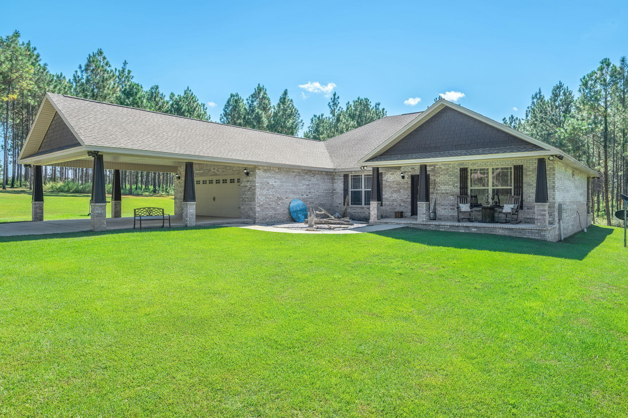 This stunning property is set amidst a picturesque 5-acre landscape with planted pines. The all-brick construction houses a 3-bedroom, 2-bathroom interior, complemented by an additional flex space, currently utilized as an office, offering endless possibilities. The home's open floor plan seamlessly integrates with the spacious living room, showcasing a stone fireplace. The kitchen boasts rich, dark wood cabinetry, granite countertops, stainless steel appliances, a kitchen island, and an adjoining dining room. The expansive master suite can accommodate oversized furnishings and features dual closets, dual vanities, a separate shower, and a soaking tub. A clever design element connects one of the master closets to a conveniently sized laundry room. Both additional bedrooms are generously proportioned, as is the guest bathroom, which features dual vanities. The screened-in back porch is equipped with a hot tub, perfect for relaxing evenings. Additional features include a 2-car garage, attached 2-car carport, and a spacious pole barn, ideal for storing boats, ride-on toys, and trailers. A supplementary portable carport is also situated on the property. Enjoy watching beautiful deer from your back porch....this serene country setting, located on a paved road, is mere minutes from the newly established equestrian boarding center in Laurel Hill. Termite bond currently in place.
