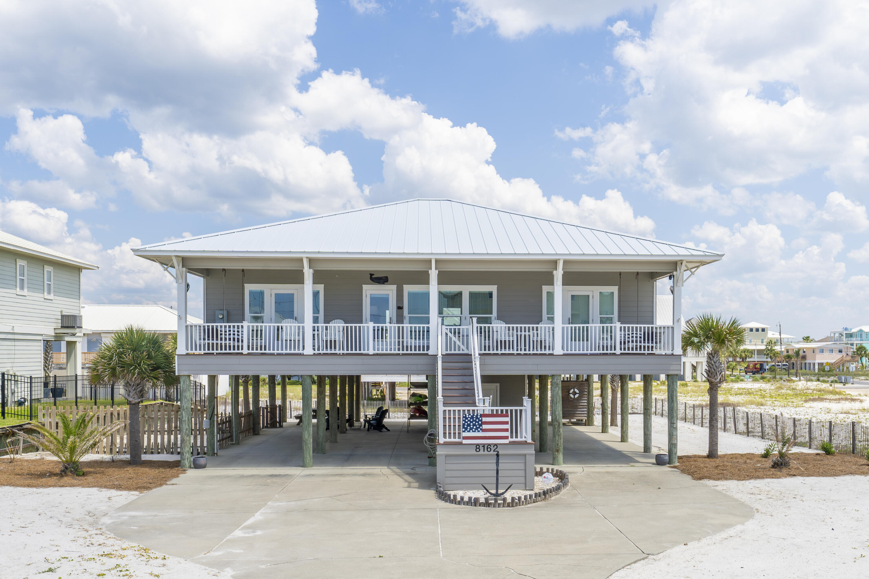 ACCEPTING BACK UP OFFERS Welcome to Whales & Anchors at 8162 Gulf Boulevard built in 2014. This beautiful never rented four-bedroom four bath southern beach house with desirable open floor plan features a deep wide porch with gulf views.  The gentle breezes beckon you to stay outdoors and curl up with a book and a glass of iced tea. Share special afternoons with family and friends as there are two large swings on each end of the porch with old-style fans moving the air.  The porch flooring is composite decking. Whales & Anchors is where boundaries of indoors and the beach seem to meld into a beautiful setting to call your happy place as every room lets on to two graciously sized porches that span the breadth of the home on the north and south sides.  and a great way to live and play with the ultimate ease on Navarre Beach.  This low maintenance beach house with cement board siding and standing seam metal roof is solidly built on pilings and designed for family fun and entertaining.  Elements of family style are reflected in this original owner's design and floor plan. In 2023 a new dishwasher, washer and dryer and refrigerator were installed, and a new HVAC system was placed in service in 2022.  The exterior was repainted within the last couple of years. The four large bedrooms can accommodate plenty of sleeping with elbow room.  The graciously sized kitchen, with ample countertop area and storage features a smart use of space as a custom wall of built ins with 23 cubbies and 3 large locker size openings provide for hanging items and can be utilized as a place to sit and take off your shoes. Grill and relax on the large back porch in the afternoons.  Bring the family and feel confident there is a place to park as six vehicles fit under the home. In addition, there is a convenient 12 x 12 storage room which houses a refrigerator and beach toys.  Ample space for a powder room.  The county beach access is approximately "six houses away "or about 800 feet in distance and there's parking if you do not choose to stroll to the beach.  We invite you to visit Whales & Anchors and consider making plans to call this your Navarre Beach getaway! 