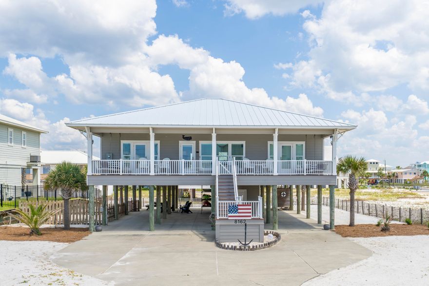 ACCEPTING BACK UP OFFERS Welcome to Whales & Anchors at 8162 Gulf Boulevard built in 2014. This beautiful never rented four-bedroom four bath southern beach house with desirable open floor plan features a deep wide porch with gulf views.  The gentle breezes beckon you to stay outdoors and curl up with a book and a glass of iced tea. Share special afternoons with family and friends as there are two large swings on each end of the porch with old-style fans moving the air.  The porch flooring is composite decking. Whales & Anchors is where boundaries of indoors and the beach seem to meld into a beautiful setting to call your happy place as every room lets on to two graciously sized porches that span the breadth of the home on the north and south sides.   and a great way to live and play with the ultimate ease on Navarre Beach.  This low maintenance beach house with cement board siding and standing seam metal roof is solidly built on pilings and designed for family fun and entertaining.  Elements of family style are reflected in this original owner's design and floor plan. In 2023 a new dishwasher, washer and dryer and refrigerator were installed, and a new HVAC system was placed in service in 2022.  The exterior was repainted within the last couple of years. The four large bedrooms can accommodate plenty of sleeping with elbow room.  The graciously sized kitchen, with ample countertop area and storage features a smart use of space as a custom wall of built ins with 23 cubbies and 3 large locker size openings provide for hanging items and can be utilized as a place to sit and take off your shoes. Grill and relax on the large back porch in the afternoons.  Bring the family and feel confident there is a place to park as six vehicles fit under the home. In addition, there is a convenient 12 x 12 storage room which houses a refrigerator and beach toys.  Ample space for a powder room.  The county beach access is approximately "six houses away "or about 800 feet in distance and there's parking if you do not choose to stroll to the beach.  We invite you to visit Whales & Anchors and consider making plans to call this your Navarre Beach getaway!
