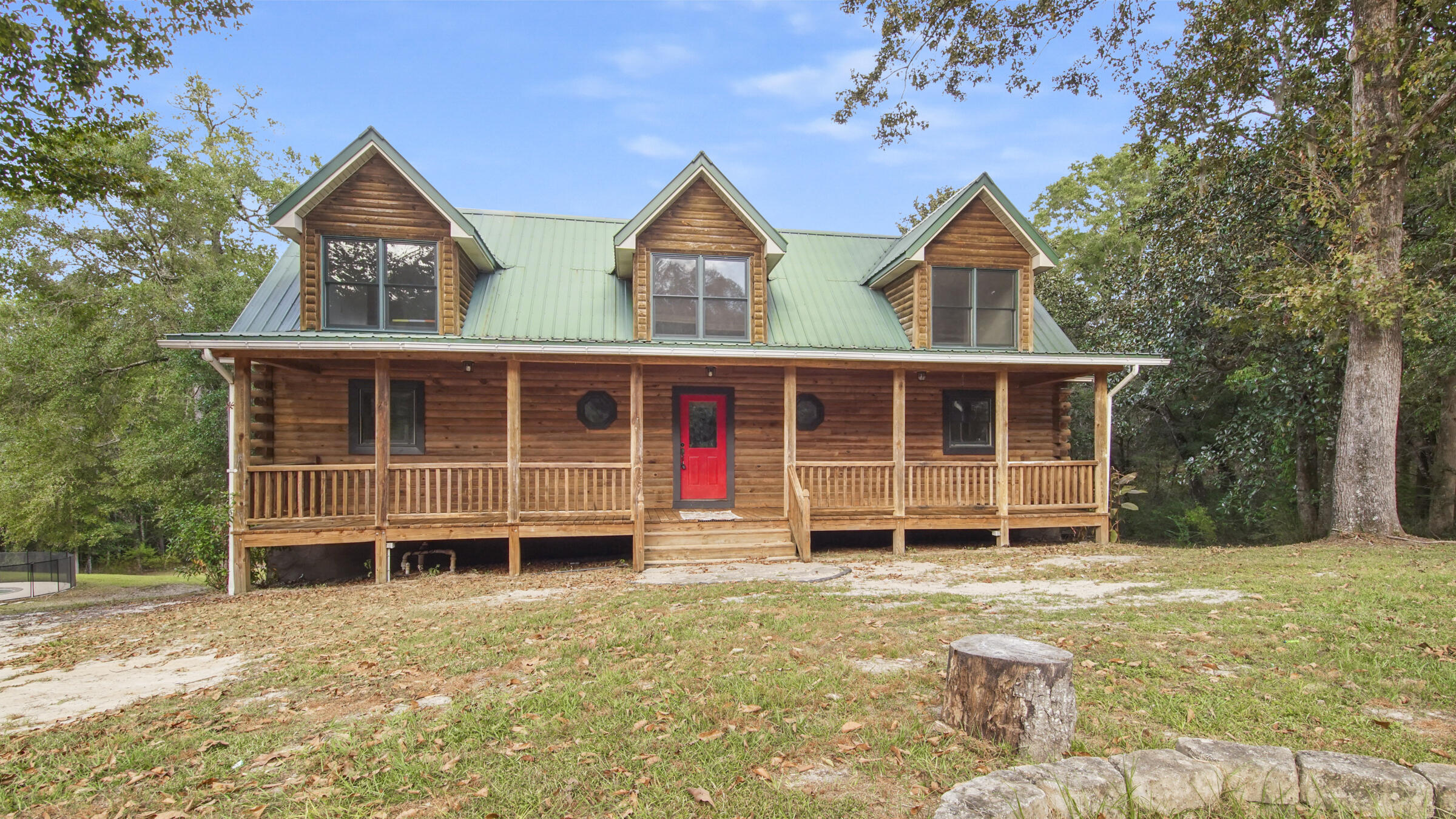 The ultimate log cabin on 9 gently rolling acres featuring a stream and in-ground pool, only 6 miles to downtown DeFuniak Springs. The partially finished heated & cooled 1344SF basement has its own HVAC unit and tons of potential. It feels like a mountain getaway with soaring cathedral ceilings in the 2100SF 3 bed/2.5 bath cabin and views to the back yard & one-time pond (could be restored). The downstairs master suite has private access to the back deck spanning the width of the home. The upstairs 2 bedrooms and bath have fantastic views and lots of storage. A second homesite/RV hookup is ready to go with separate well, septic & electric pole. The detached garage is equipped with 220v and has a brand new RV cover. The gunite pool finishes out the list of extras of this special property.