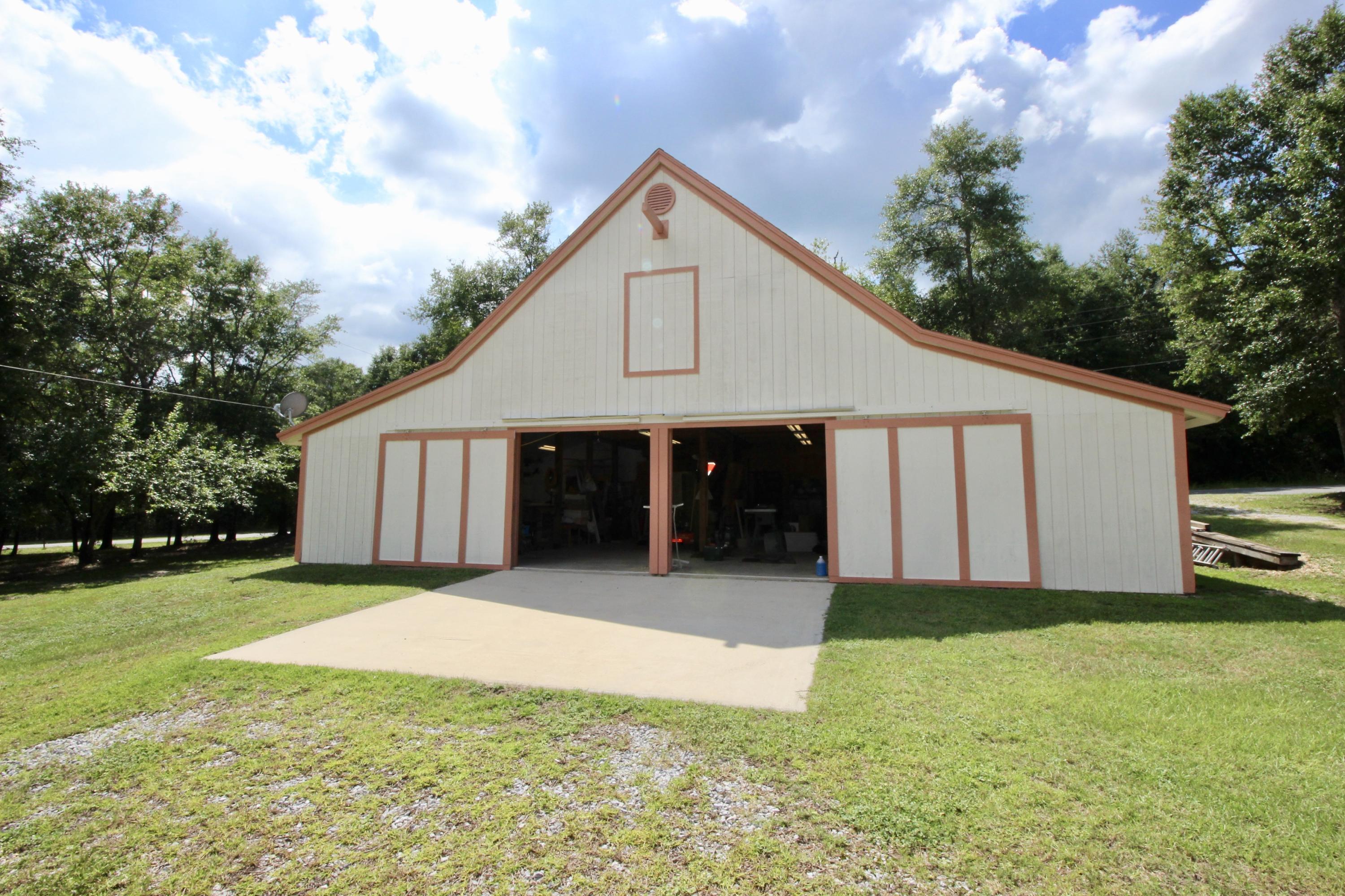 Beautiful RV-ready 1+ acre parcel with 1440 sf BARN with FULL RV Hookup including septic and power, across the street from Lake Juniper with water views. Barn also has a spacious easily accessible loft for additional storage and 2 window AC units. Small storage building for small equipment also. Lot is partially cleared. Located just a few hundred feet from public boat launch. Lake Juniper is appx 660 acres and is home to award winning bass and bream fishing - and now it's nearly at your doorstep without paying waterfront pricing. The adjoining lot may be purchased, with underbrush cleared and a number of hardwood trees - for a total of 1.62 acres. See MLS 815808.