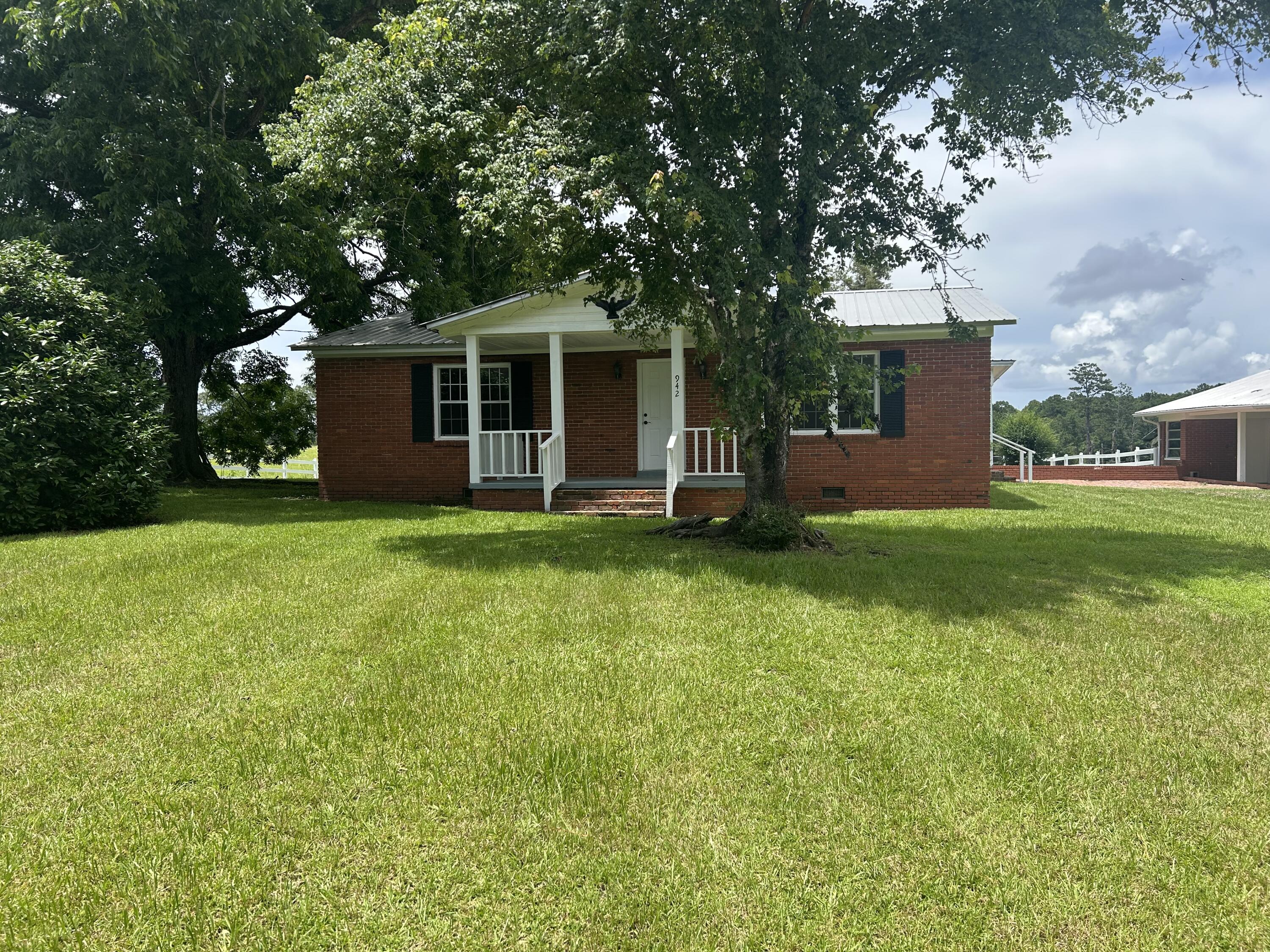 24 ACRES OF PRISTINE ROLLING PASTURELAND - OVERLOOKS A STOCKED (and in need of fishing) SEVEN ACRE LAKE that is just as absolutely gorgeous, as gorgeous private lakes go! There is also a VERY LARGE 50X60 POLE BARN in addition to the 1800 SF existing brick home. Lots of original pine hardwood walls and original hardwood flooring too. It could be fixed up really rustic. This property is also perfect for a multiple home family compound, a church retreat and campground, or for the perfect single hilltop homesite with that incredible pastureland lakeview (and guest house the existing home). Two car carport with storage rooms, side porch and brick patio. Plenty of fencing to keep horses, cows, kids and dogs in. Sale subject to final probate-call to see today.