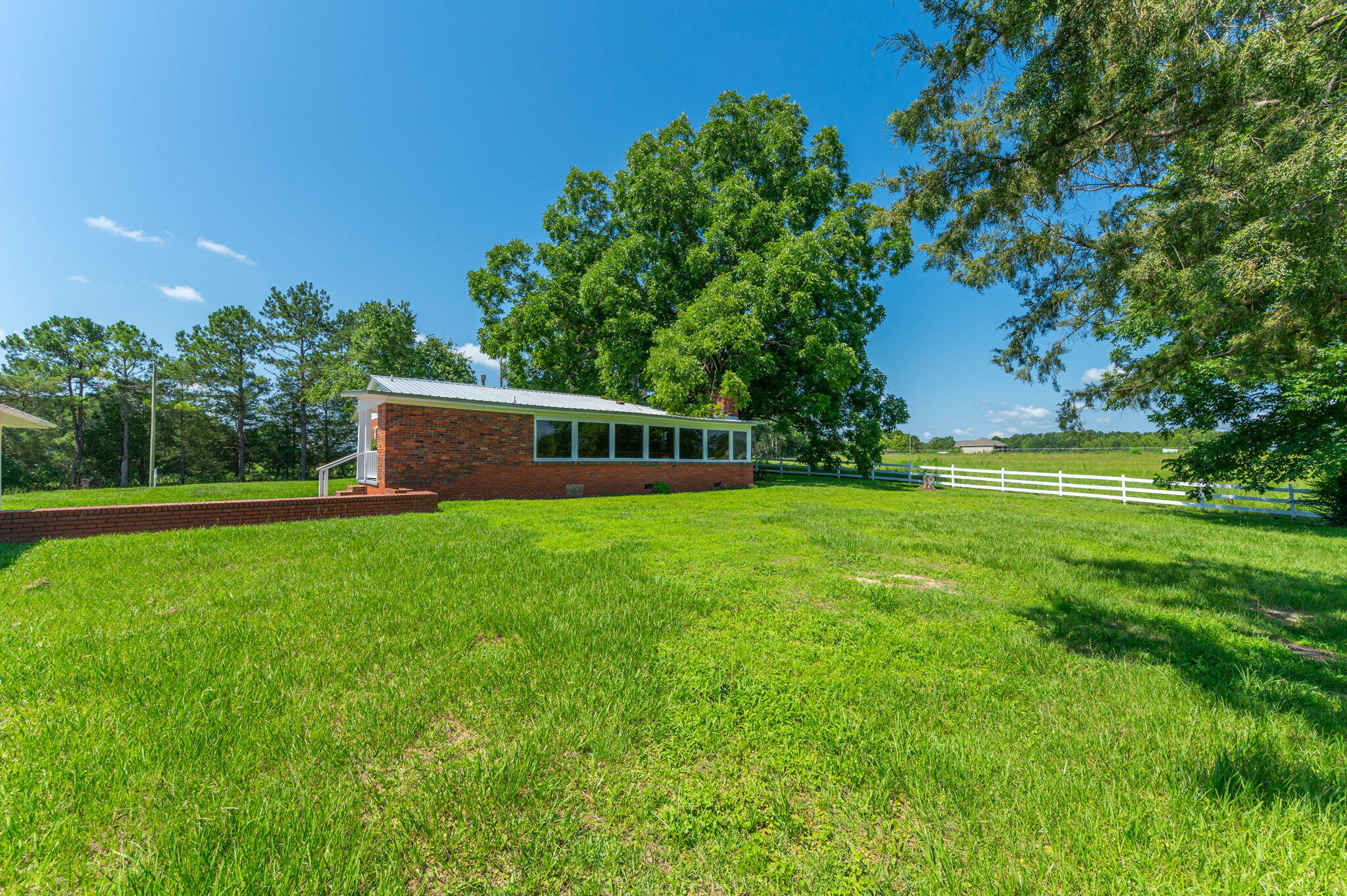 24 ACRES OF PRISTINE ROLLING PASTURELAND - OVERLOOKS A STOCKED (and in need of fishing) SEVEN ACRE LAKE that is just as absolutely gorgeous, as gorgeous private lakes go! There is also a VERY LARGE 50X60 POLE BARN in addition to the 1800 SF existing brick home. Lots of original pine hardwood walls and original hardwood flooring too. It could be fixed up really rustic. This property is also perfect for a multiple home family compound, a church retreat and campground, or for the perfect single hilltop homesite with that incredible pastureland lakeview (and guest house the existing home). Two car carport with storage rooms, side porch and brick patio. Plenty of fencing to keep horses, cows, kids and dogs in. Sale subject to final probate-call to see today.