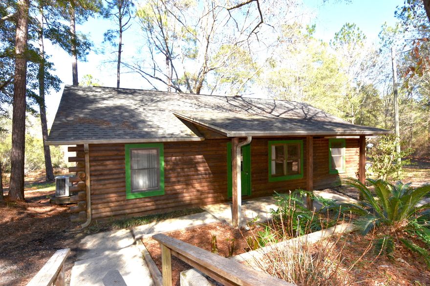 Log Cabin on 5+ acres with a private pond! The Cabin was built in 2001. There is a 1972 Mobile Home on the property, along with a detached Garage/Workshop, and Shed with Carport. Large front porch and oversized deck on the back that has additional supports for a hot tub. Zoning and Future Land Use are Agricultural. Plenty or room to roam on your own land and 10 minutes to town! Two wells on the property and Two electric meters on the property. 2 Bed/2 Bath cabin features are large living room with stone fireplace and a view through the double french doors. Galley kitchen has plenty of counter space, pantry, a view from the garden window box, and a side door to the porch. Enjoy the peace and quite on the oversized deck with a view of the pond!