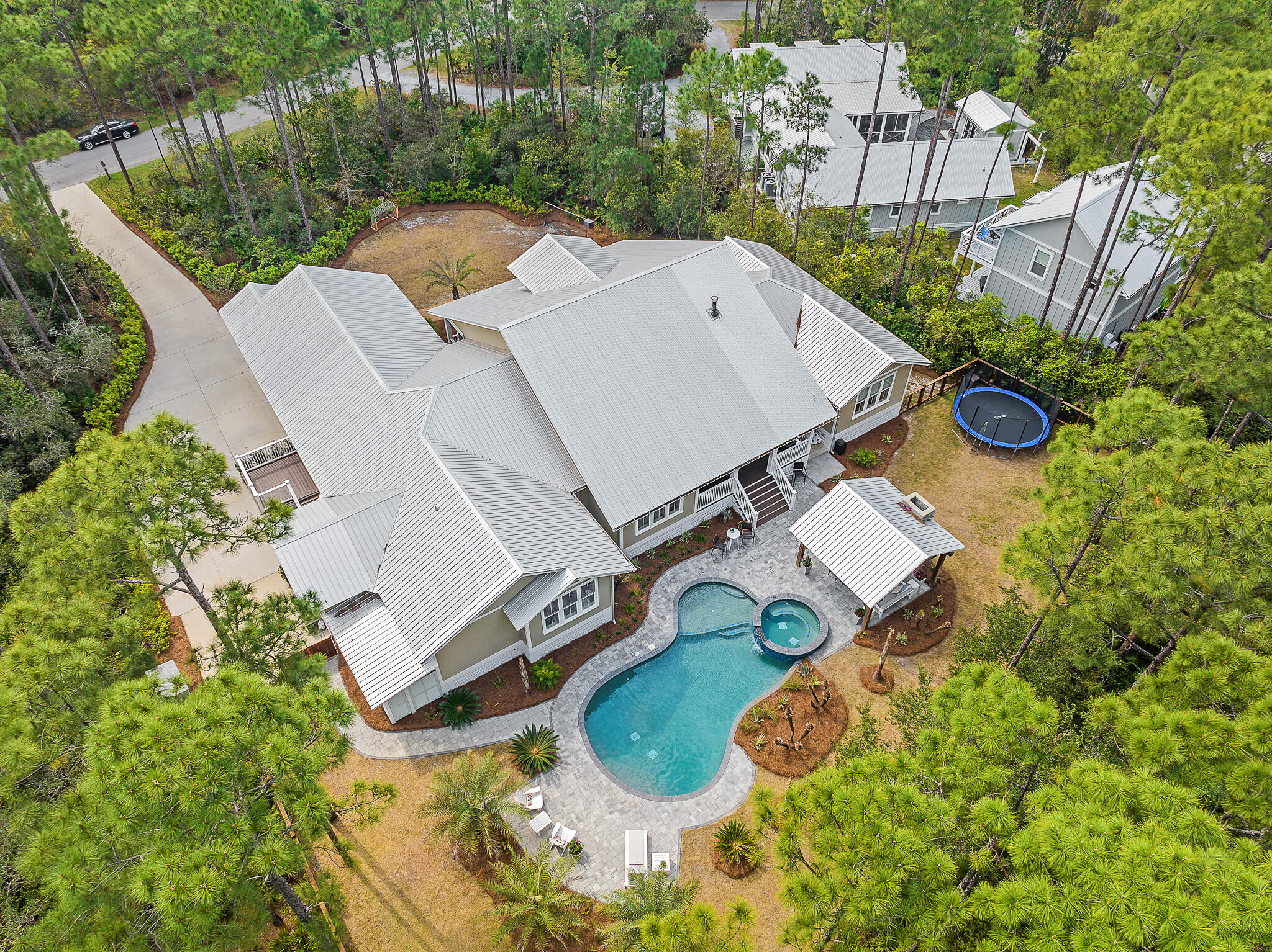 Nestled among the tall pines of a private wooded 0.6 acre estate , this custom home features over 3,900 square feet of expansive single-story living. Interior highlights include a spacious owners' suite, split floor plan, fireplace and double kitchen island. The backyard tropical oasis features a pool + spa, cabana, fireplace and lush professional landscaping. This home is located in THE WOODS, a serene bay-front community in Pt Washington. Residents enjoy a neighborhood trail and private dock on the bay, as well as easy living just minutes to schools, shopping and the white sand beaches of 30A.