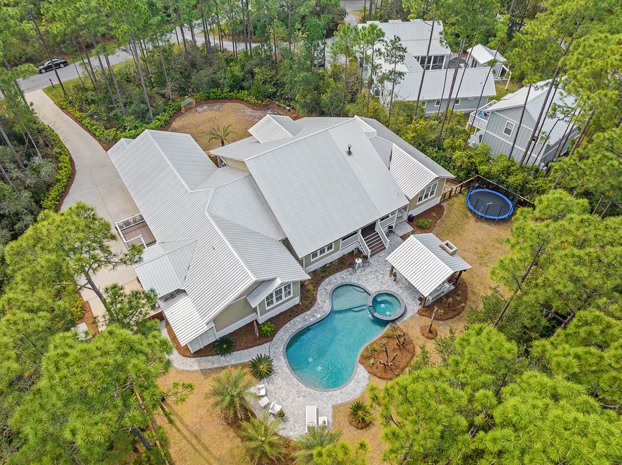 Nestled among the tall pines of a private wooded 0.6 acre estate , this custom home features over 3,900 square feet of expansive single-story living. Interior highlights include a spacious owners' suite, split floor plan, fireplace and double kitchen island. The backyard tropical oasis features a pool + spa, cabana, fireplace and lush professional landscaping. This home is located in THE WOODS, a serene bay-front community in Pt Washington. Residents enjoy a neighborhood trail and private dock on the bay, as well as easy living just minutes to schools, shopping and the white sand beaches of 30A.