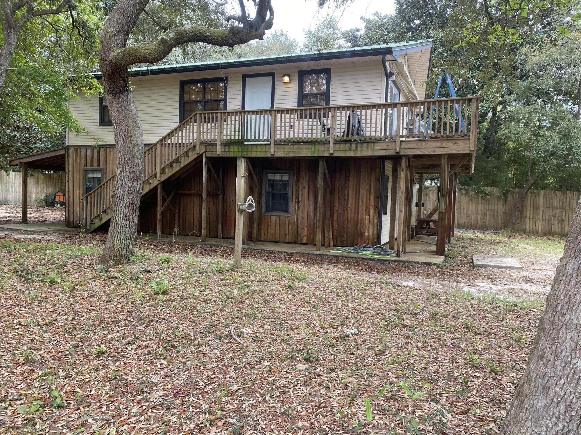 Tucked away in the laid-back coastal charm of Navarre, this two-story country apartment offers the perfect blend of tranquility, functionality, and income opportunity. Surrounded by mature Magnolia and Live Oak trees, the property exudes sunshine and natural shade all year round. Whether you're looking for a full-time residence, a vacation getaway, or a smart investment, this property checks all the boxes. Close to the beaches and activities yet serene and private. Close to the boat ramp for an added bonus! With room to grow, space to work or play, and income-generating potential, this is a rare find in one of Florida's most beloved beach towns. A true gem for those seeking peace, potential, and a taste of the coastal country lifestyle!