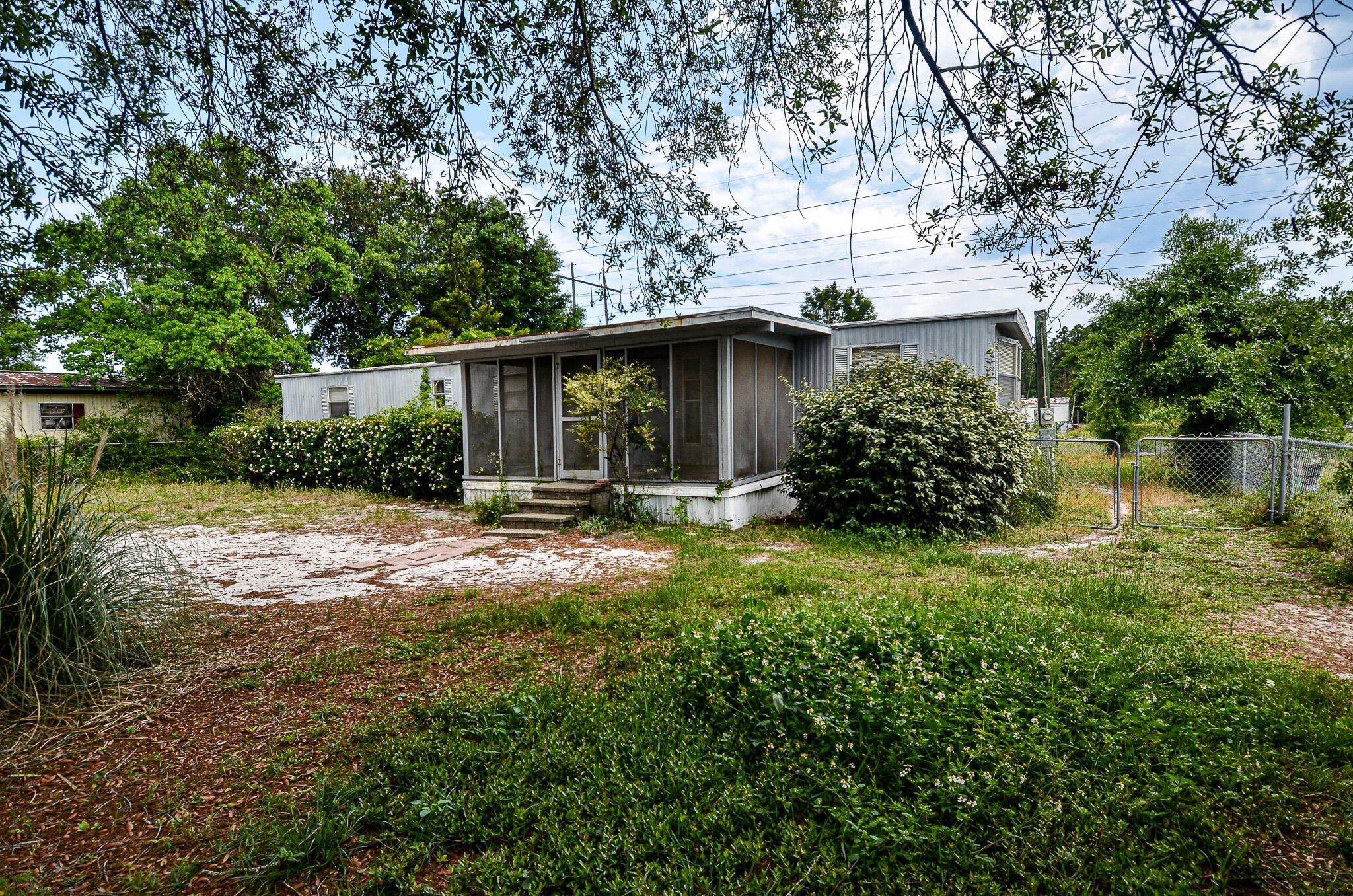 This home is on .321 acres and has an existing 1976 manufactured home in place that has been a rental property for many years. This 2 bedroom, 1 bath home could be used as a rental, primary residence or removed to build a new home. The house has a metal roof with peel and stick, central air and is in overall good condition. Could be gutted and remodeled. Cash Buyers only.