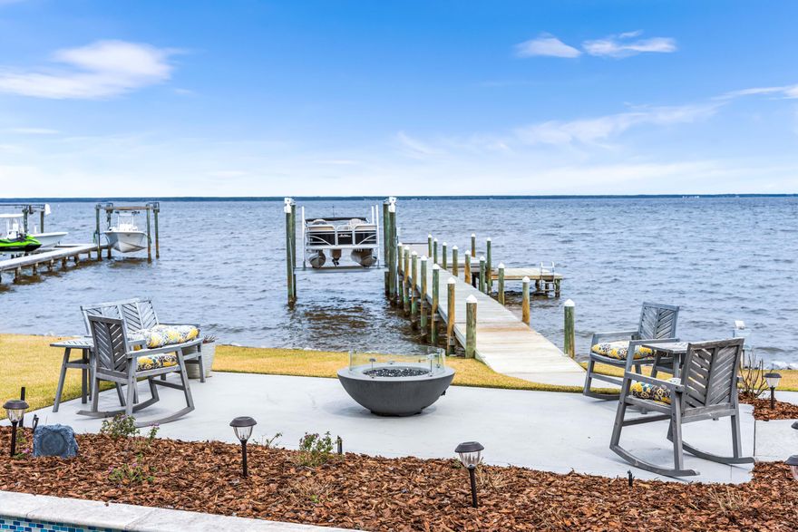 Welcome to your dream retreat ON THE BAY! This exquisite custom design build by Romair Construction offers unparalleled luxury living, complete with its own private boat dock featuring a swim platform and 6,000 lb boat hoist. Step inside to discover an inviting open floor plan designed for effortless entertaining, highlighted by expansive windows that flood the space with natural light and showcase breathtaking views of the bay.Indulge in the comforts of a spacious primary en suite, featuring a luxurious tile shower, double vanity,  and an expansive walk-in closet. Enjoy direct access to the incredible backyard oasis, where you can unwind and soak in the stunning sunsets.