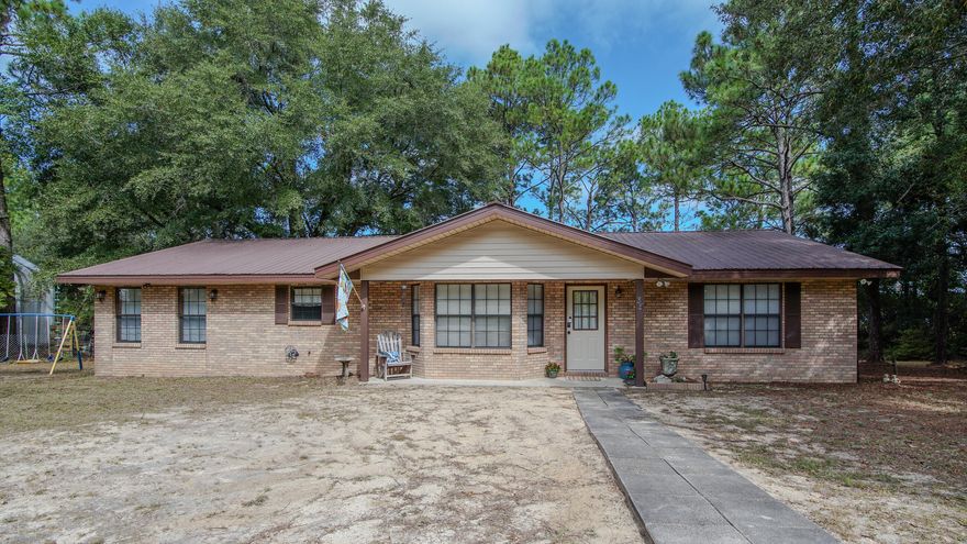 Charming and ready-to-enjoy 4 BR/2BA waterfront home on beautiful Juniper Lake.  Enjoy peaceful lake views from your back deck or if that isn't enough, you are less than an hours drive to the beach. Inside, you'll find an open concept layout, updated flooring, and kitchen appliances that are less than three years old.  Metal roof is 9 years old and hot water heater replaced in 2022.   All four bedrooms are spacious, and there's a separate utility area for added convenience. Got hobbies or need extra storage? The detached garage/workshop has you covered. Sitting on .84 acres with a circular drive, this home's clean, move-in ready, and great for a big crew. Don't miss this rare lakefront gem!